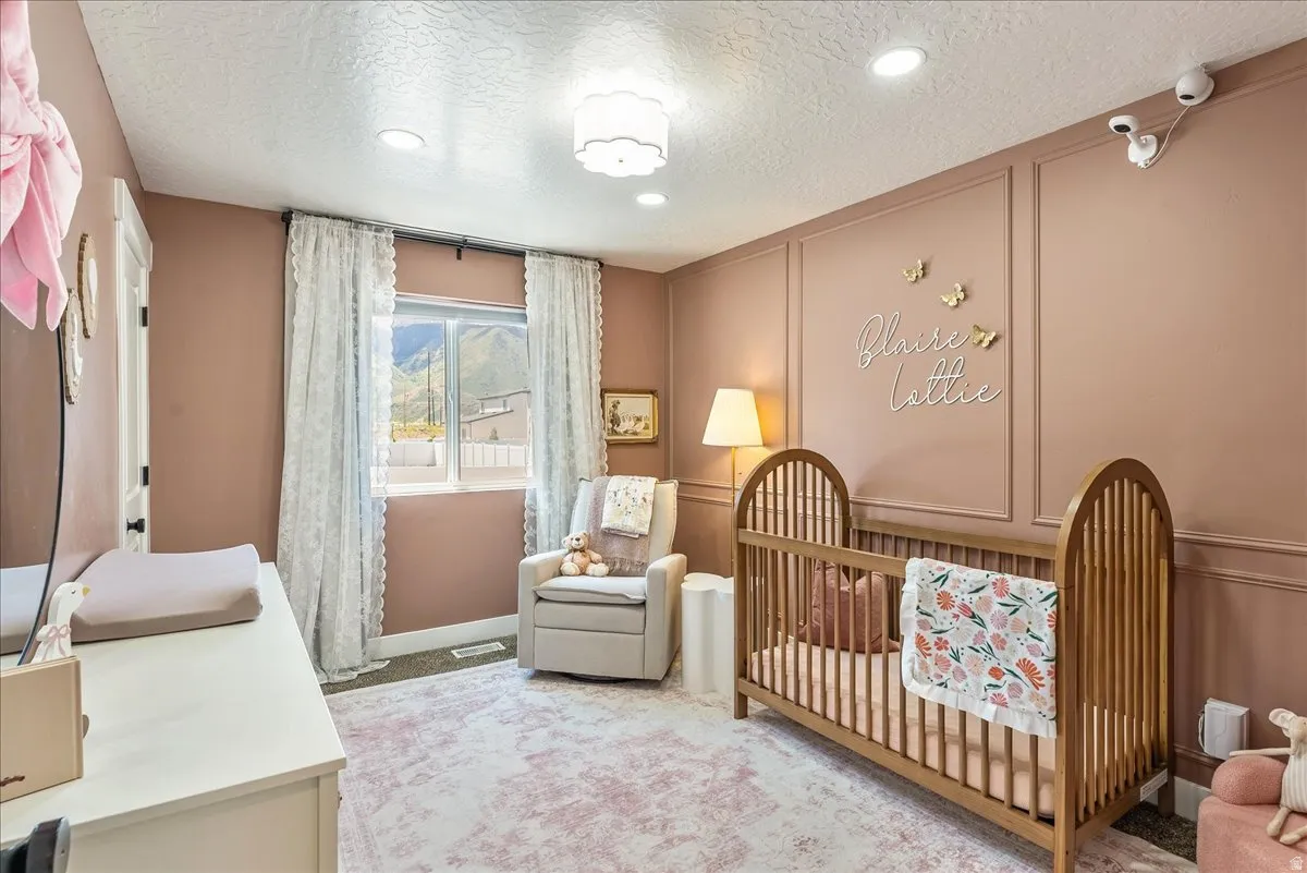 Room featuring a single window with white lace curtains, recessed lighting, and a decorative ceiling fixture