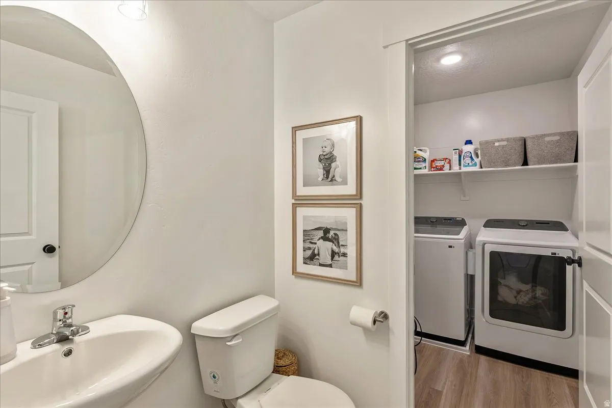 Convenient laundry closet featuring built-in shelving, wood-finish flooring, and a recessed light