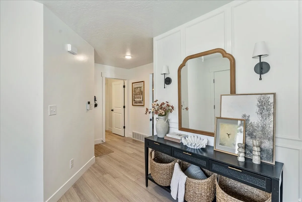 Entryway featuring light wood-finish flooring, white walls, and a decorative console table