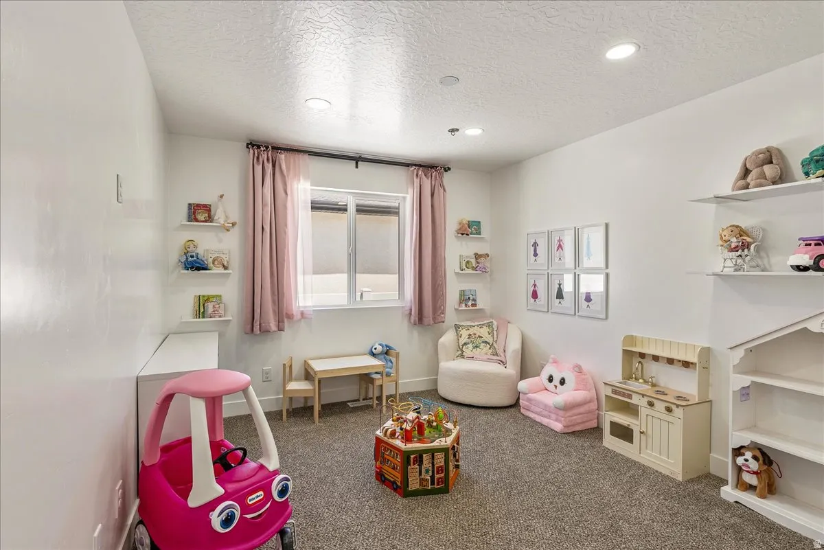Carpeted room featuring recessed lighting, a window with pink curtains, and white floating shelves