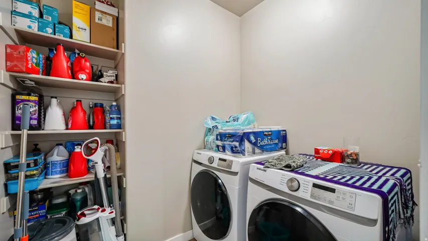 Dedicated laundry area featuring a built-in shelving unit providing ample storage space