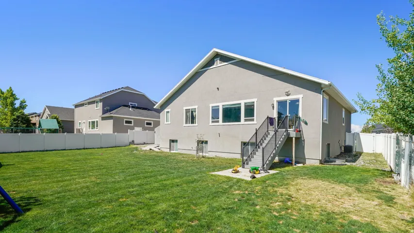Expansive backyard featuring a manicured lawn and a privacy fence