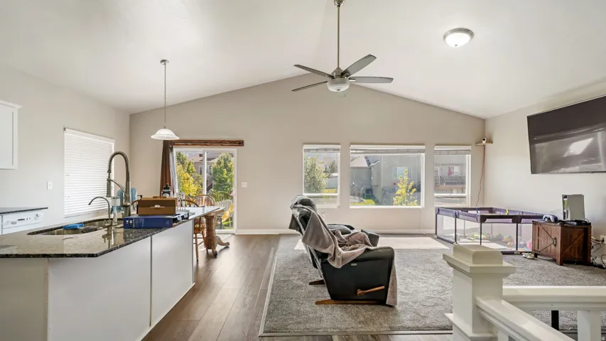 Open-concept living area featuring a vaulted ceiling and LVP flooring in traffic areas.