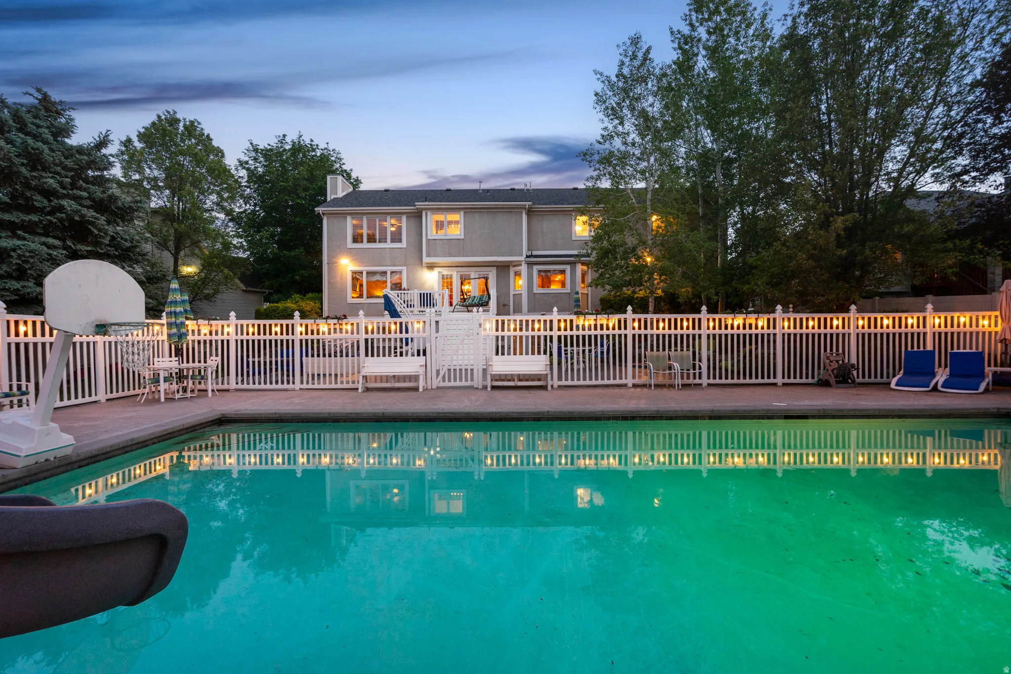 Expansive backyard featuring a large swimming pool with concrete surround