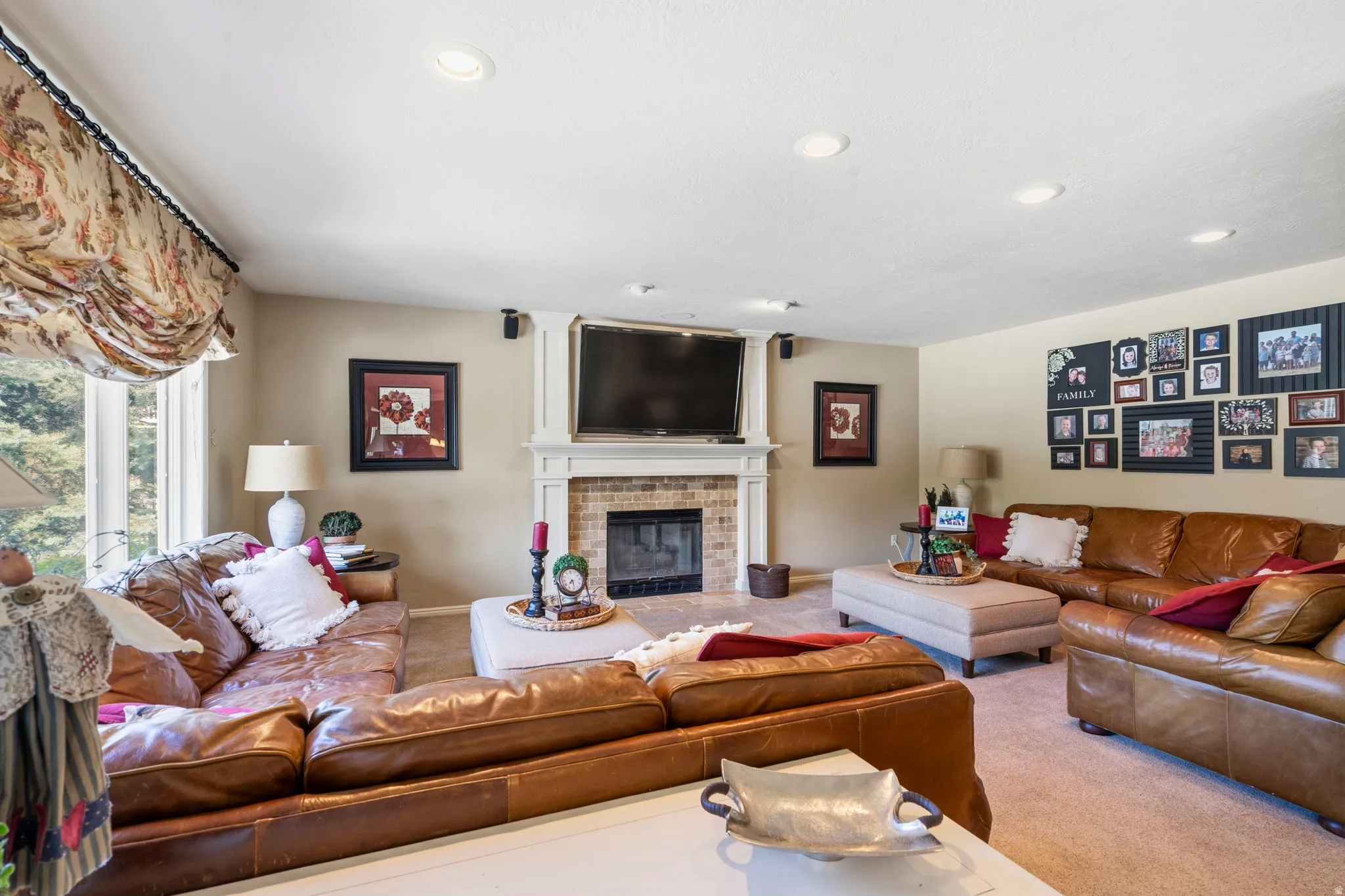 Spacious living area featuring a brick fireplace with a white mantel, recessed lighting, and a large window