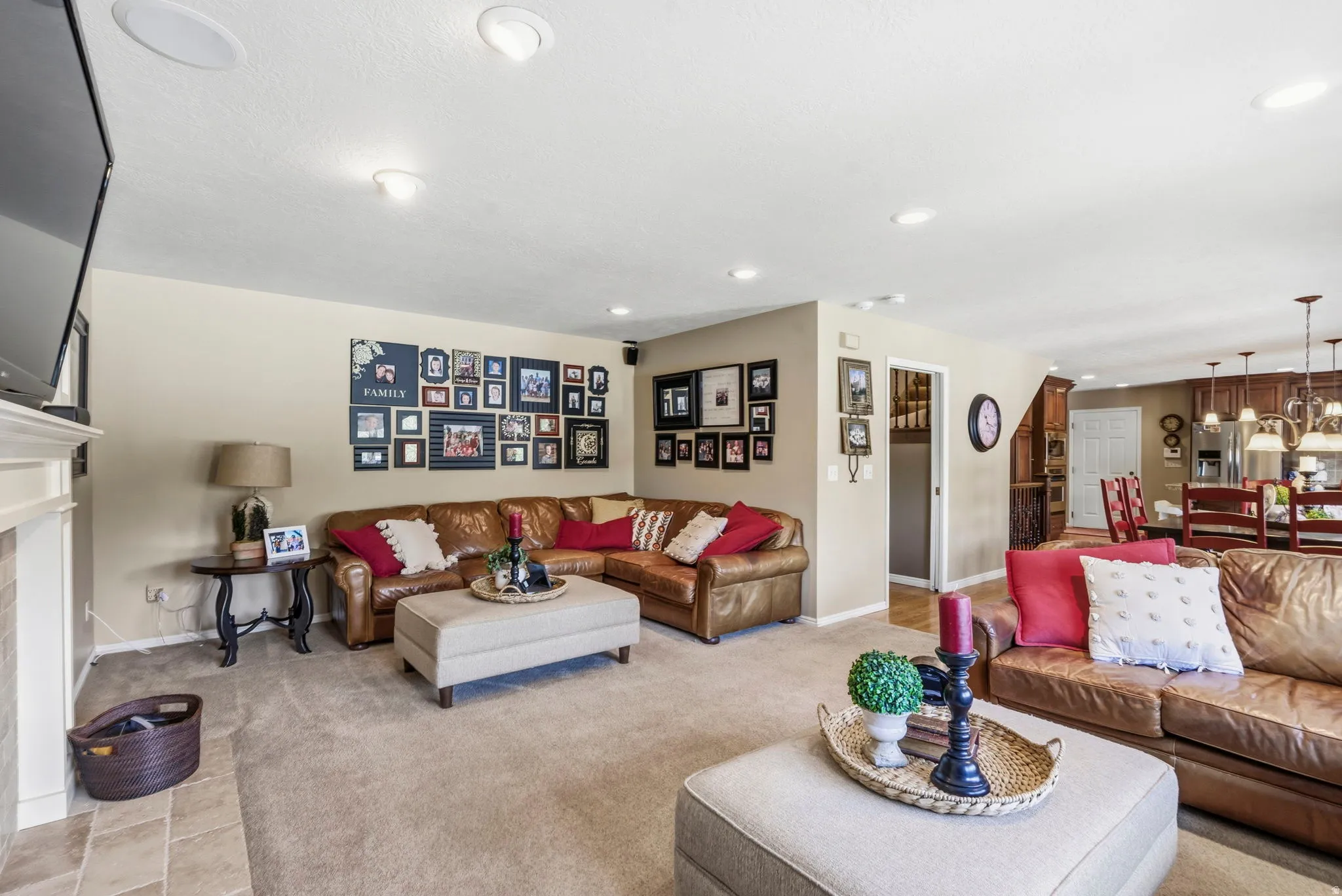 Open concept living space featuring recessed lighting, a fireplace with a light-colored mantel, and carpeted flooring