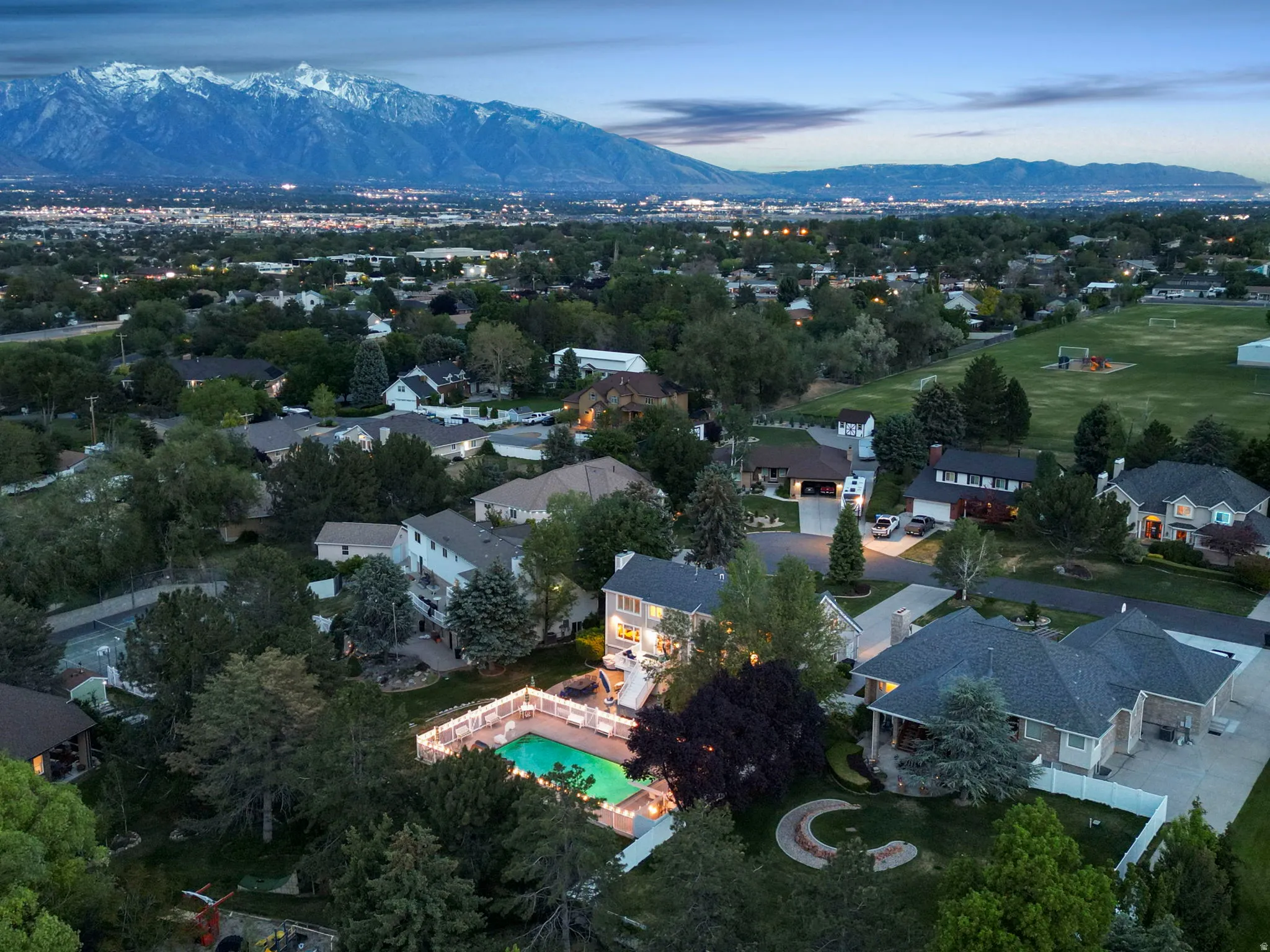 Aerial panorama showcasing a residential neighborhood with distant snow-capped mountains