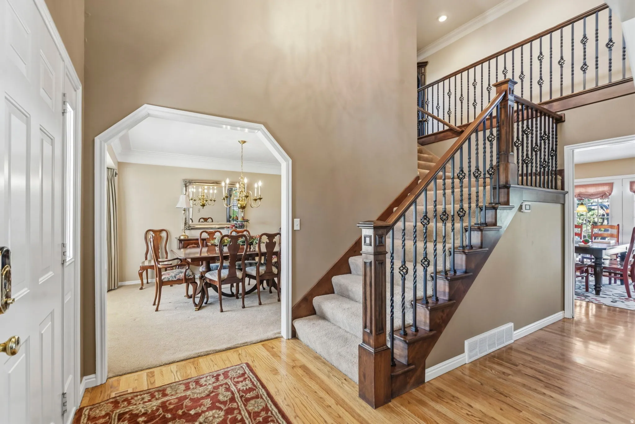 Grand staircase featuring wood railings and wrought iron balusters