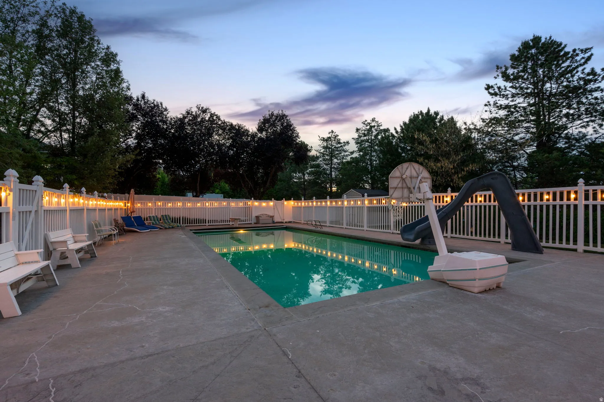 Expansive concrete pool deck surrounding a rectangular in-ground swimming pool