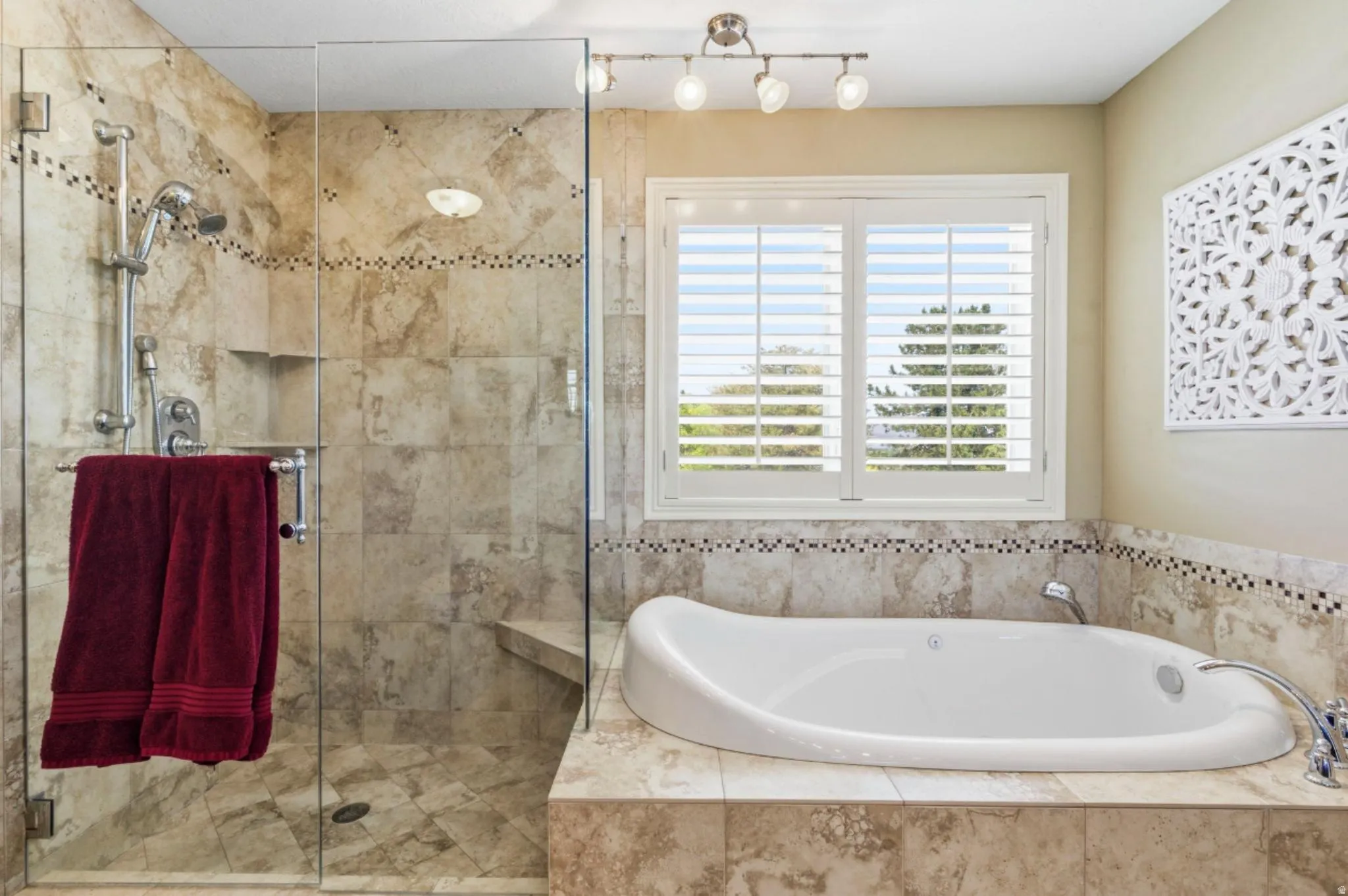 Freestanding soaking tub and glass-enclosed shower with a built-in bench