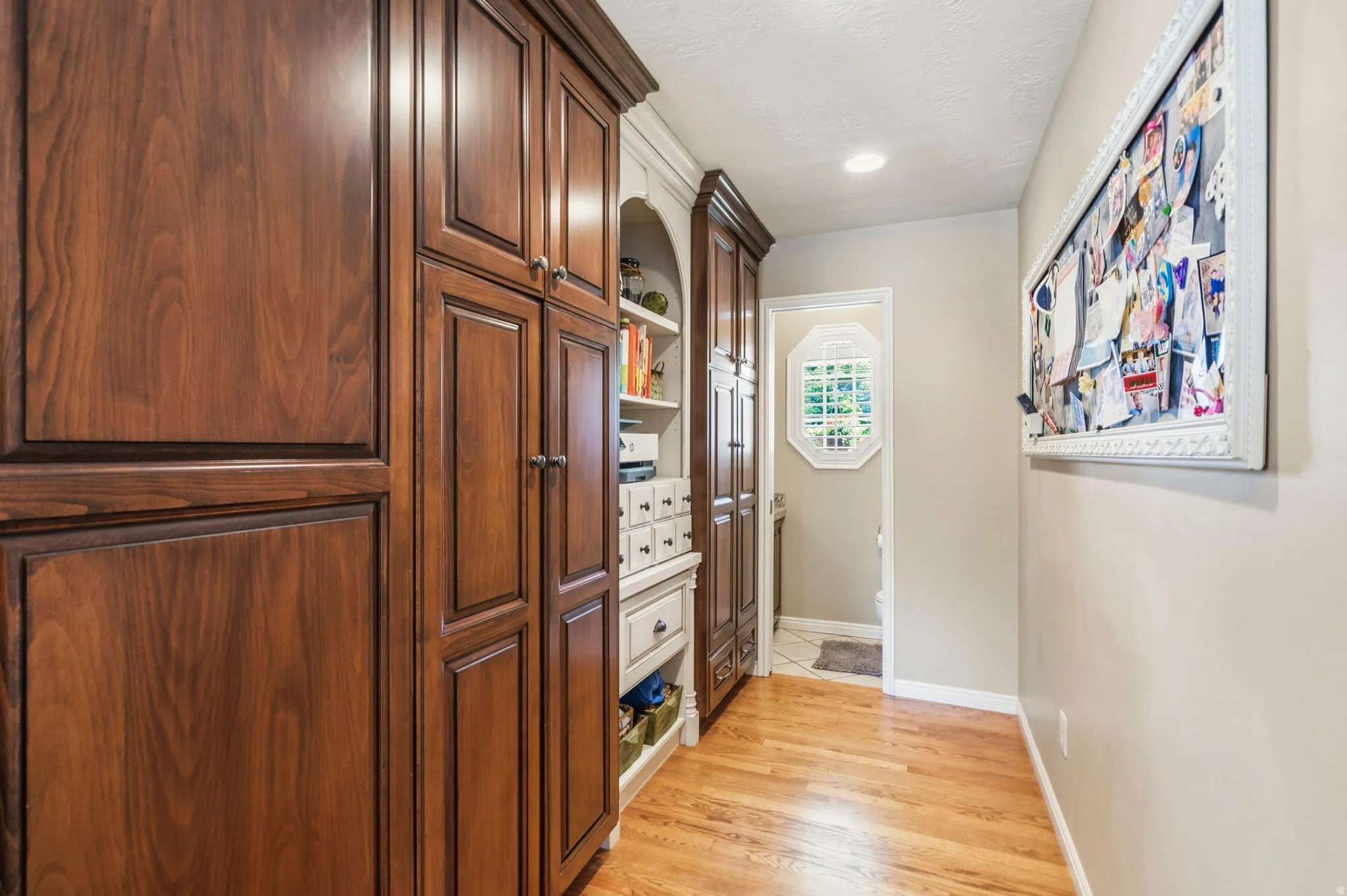 Rich wood-finish cabinetry providing extensive storage, complemented by light wood-finish flooring