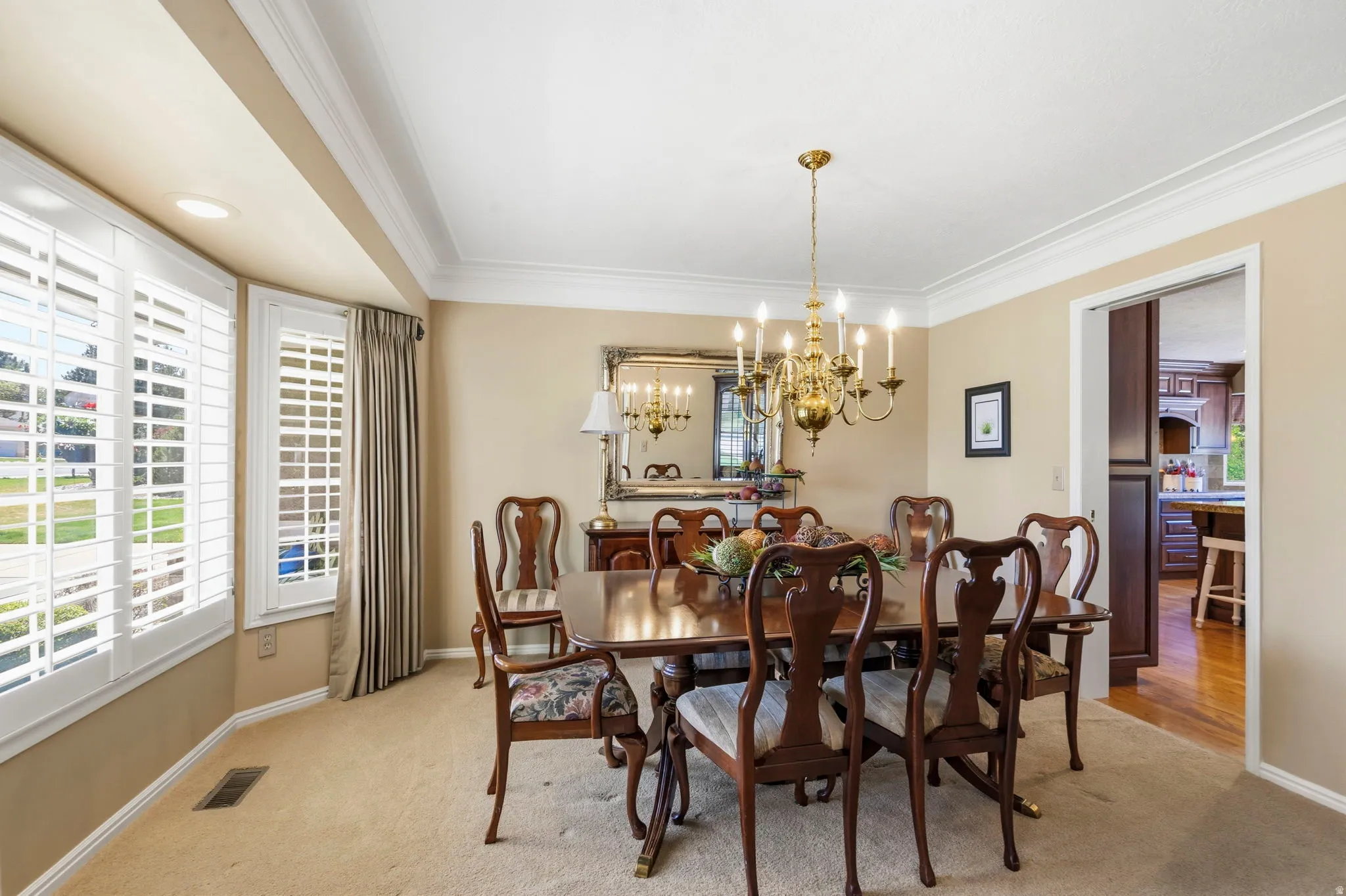 Formal dining space featuring crown molding and a brass chandelier