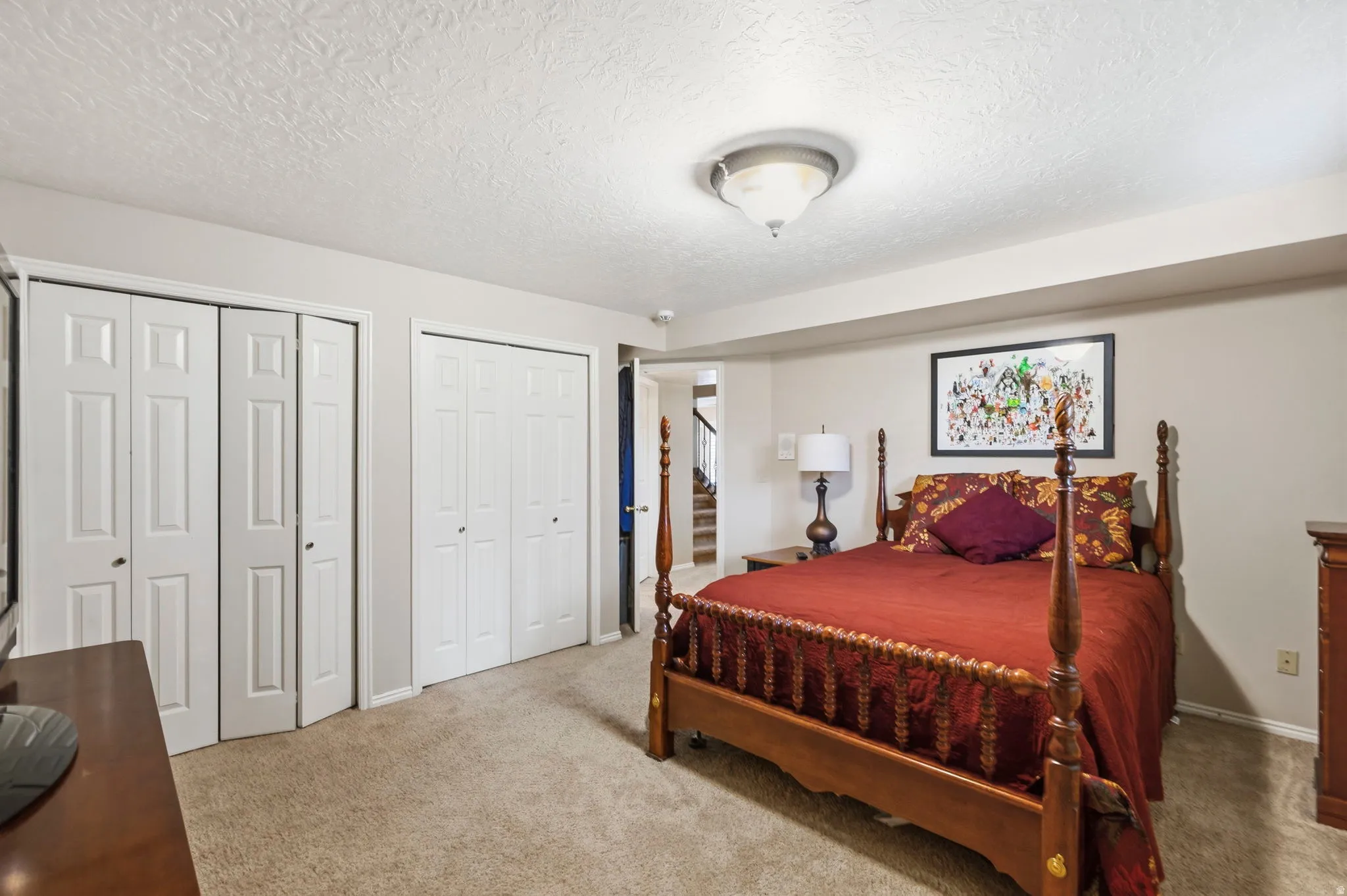 Carpeted room featuring two bi-fold door closets, recessed lighting, and neutral wall paint