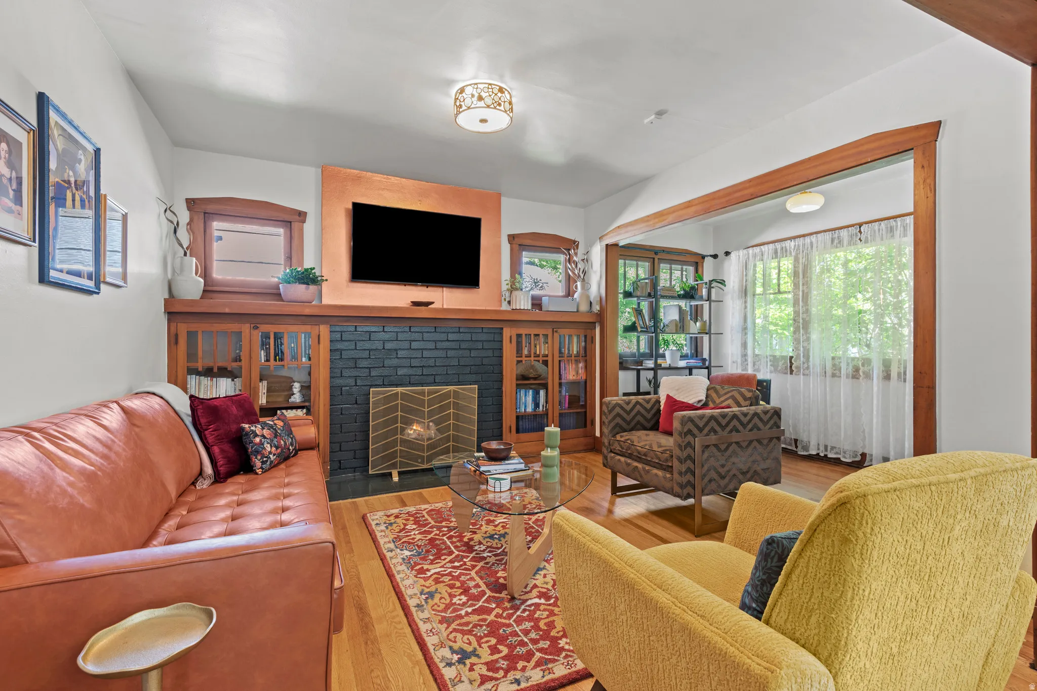 Living room with charming original woodwork, a new fireplace insert, and hardwood floors