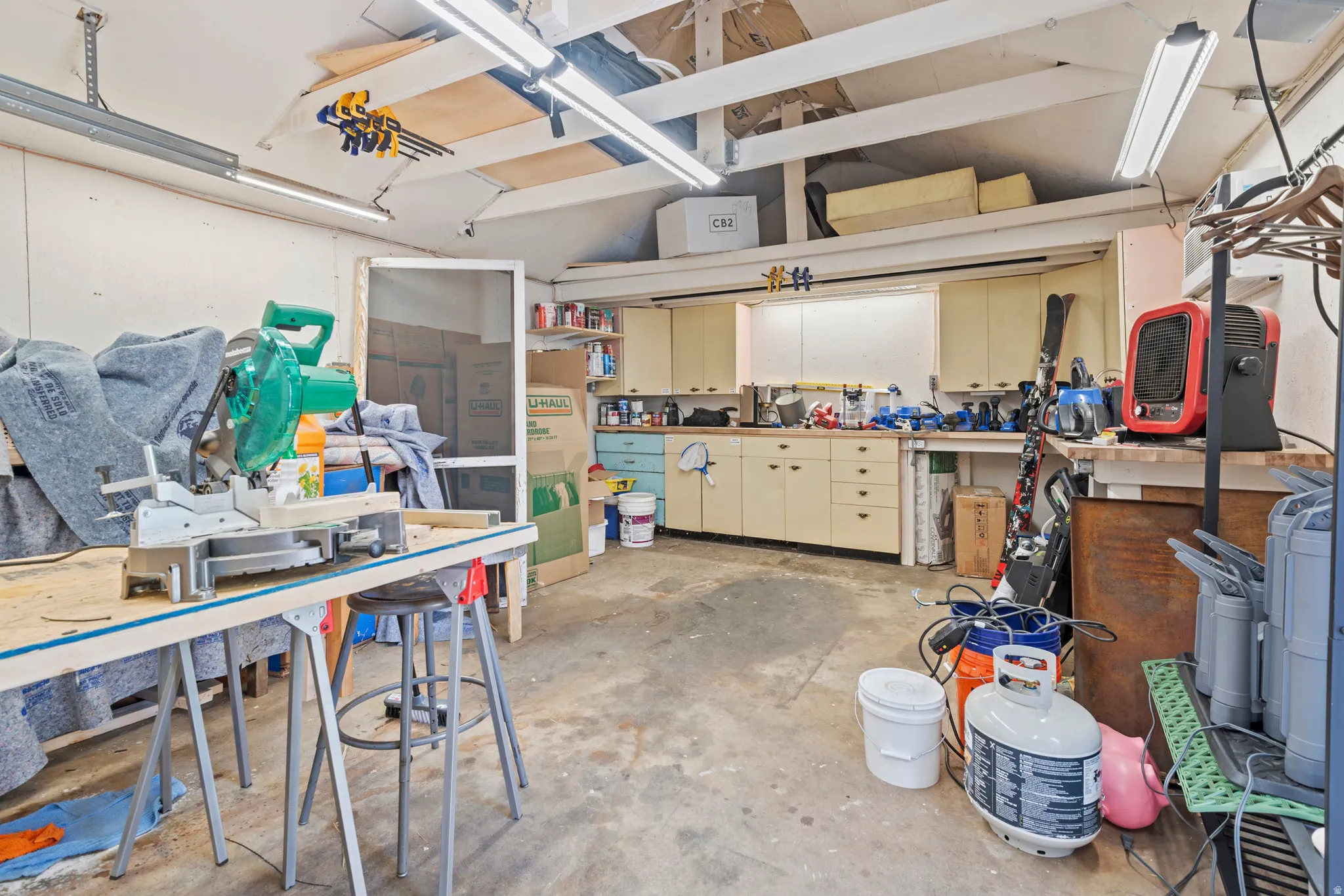 Garage or workspace with a generous workbench with comfortable heating and air conditioning! One could spend some time out here.