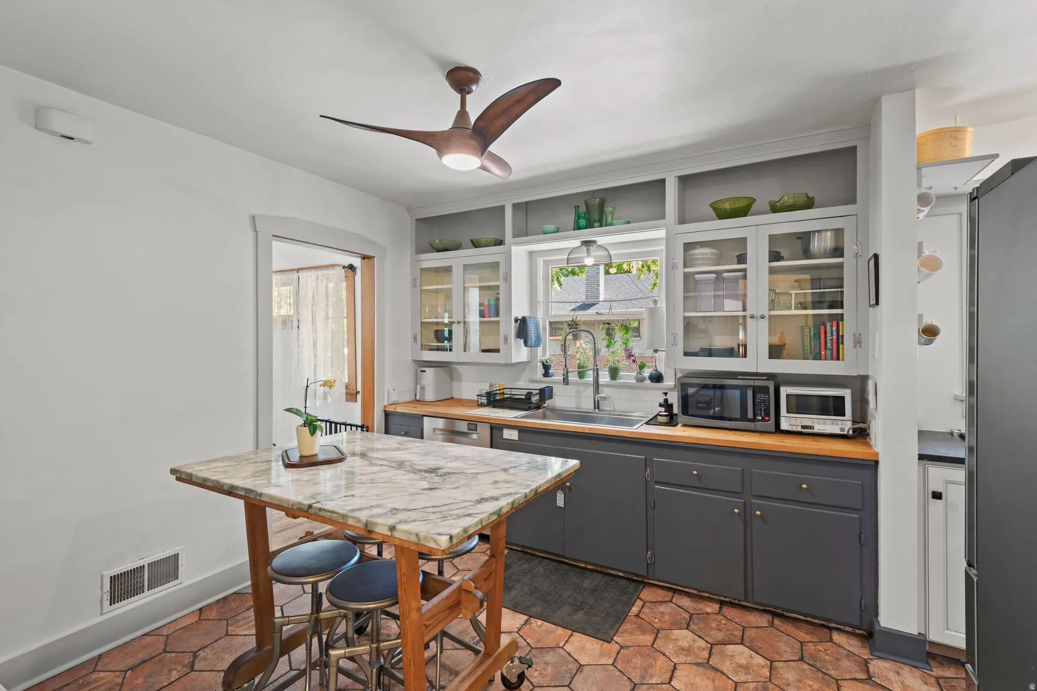 Kitchen featuring  butcher block and granite countertops, original glass-front cabinetry