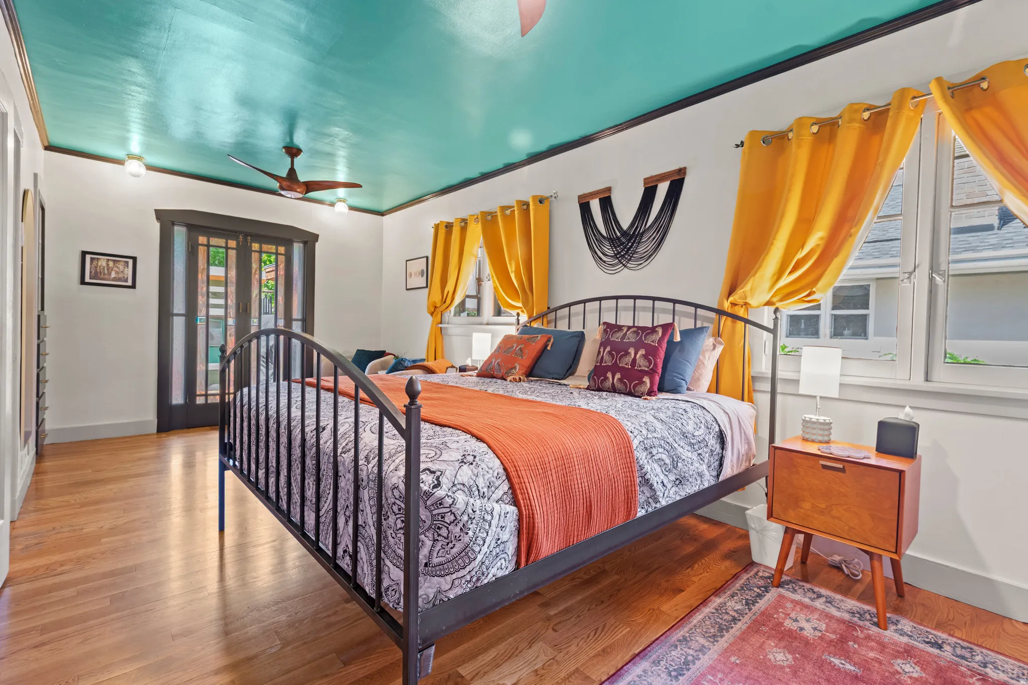Large and bright primary bedroom with hardwood flooring throughout. Charming vintage doors to the amazing back yard