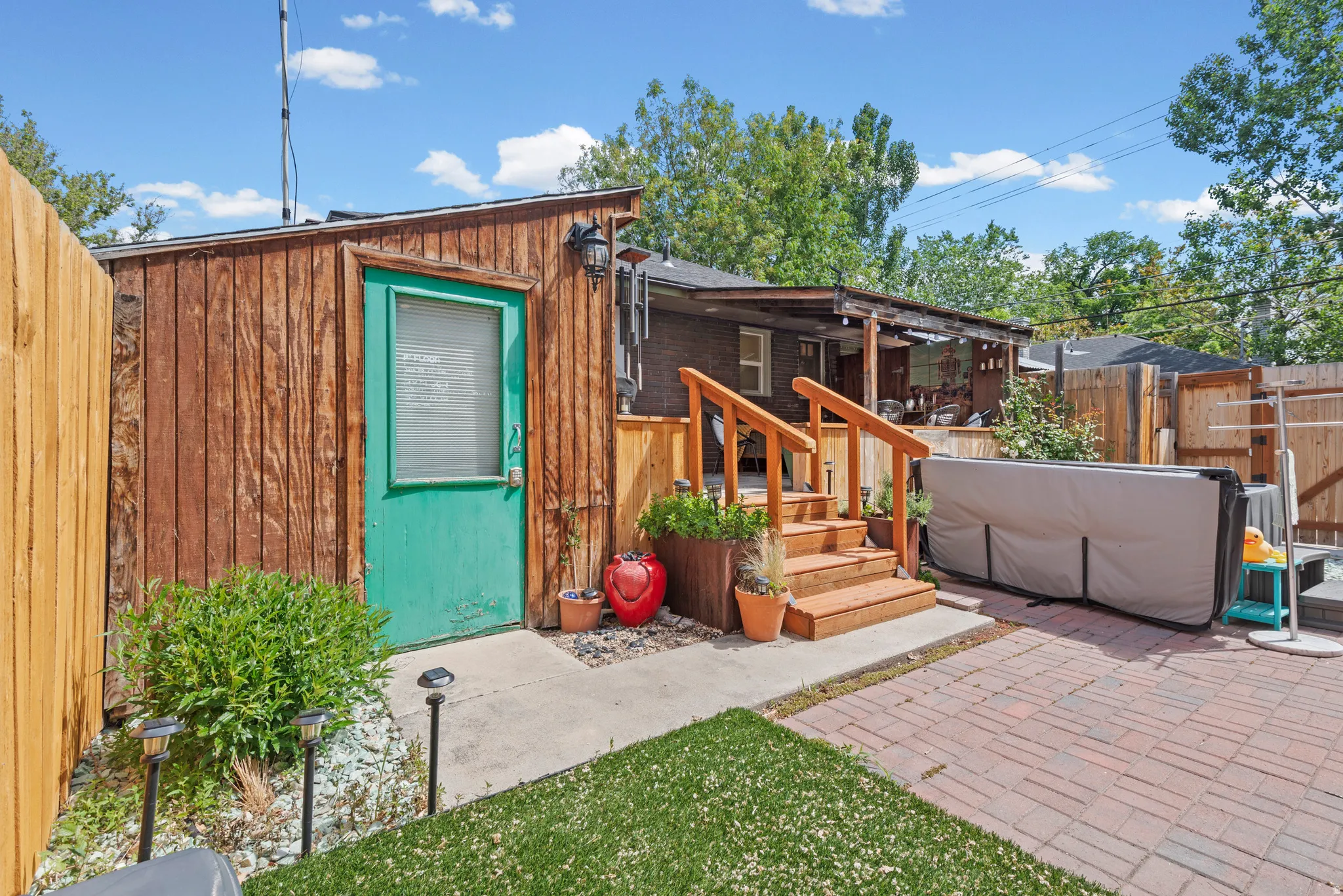 Covered deck, patio featuring brick pavers, a wood-sided shed for extra storage or garden shed. Enjoy that included hot tub!