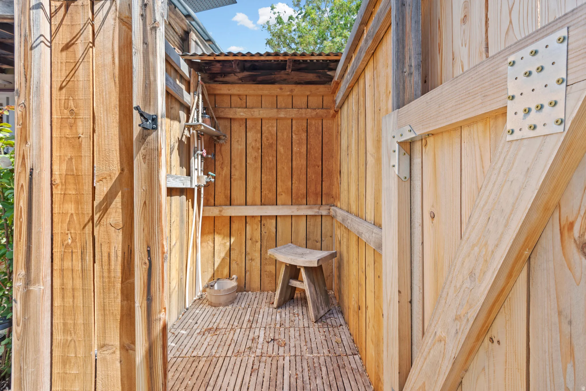 Outdoor shower enclosure crafted from natural wood planks - private and convenient when in and out of the included hot tub