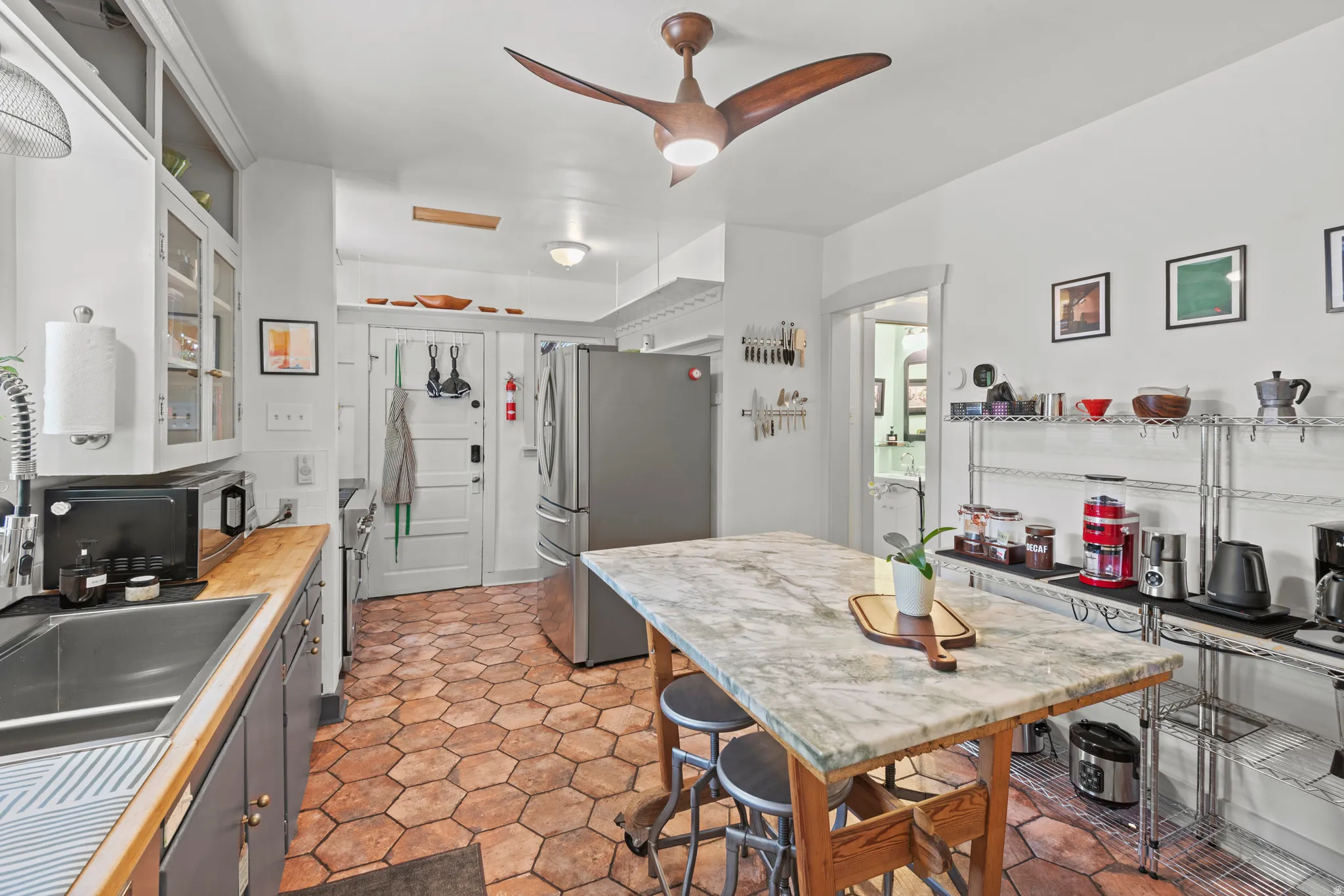 Kitchen featuring a striking island topped with green-veined marble and crafted from an authentic Scandinavian farm table