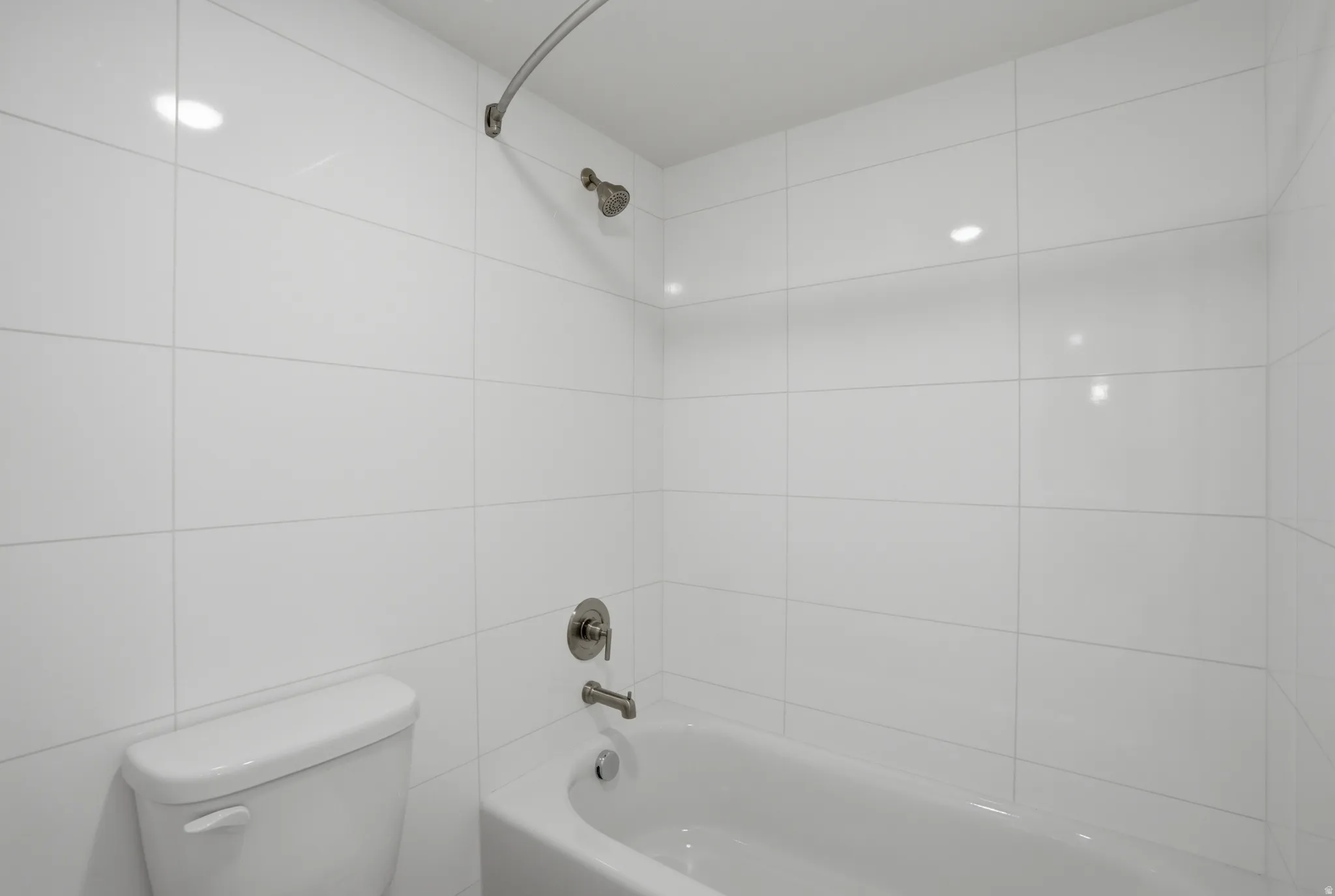 White subway tile shower surround featuring a built-in tub