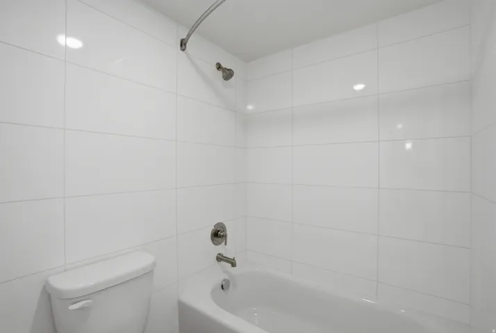 White subway tile shower surround featuring a built-in tub