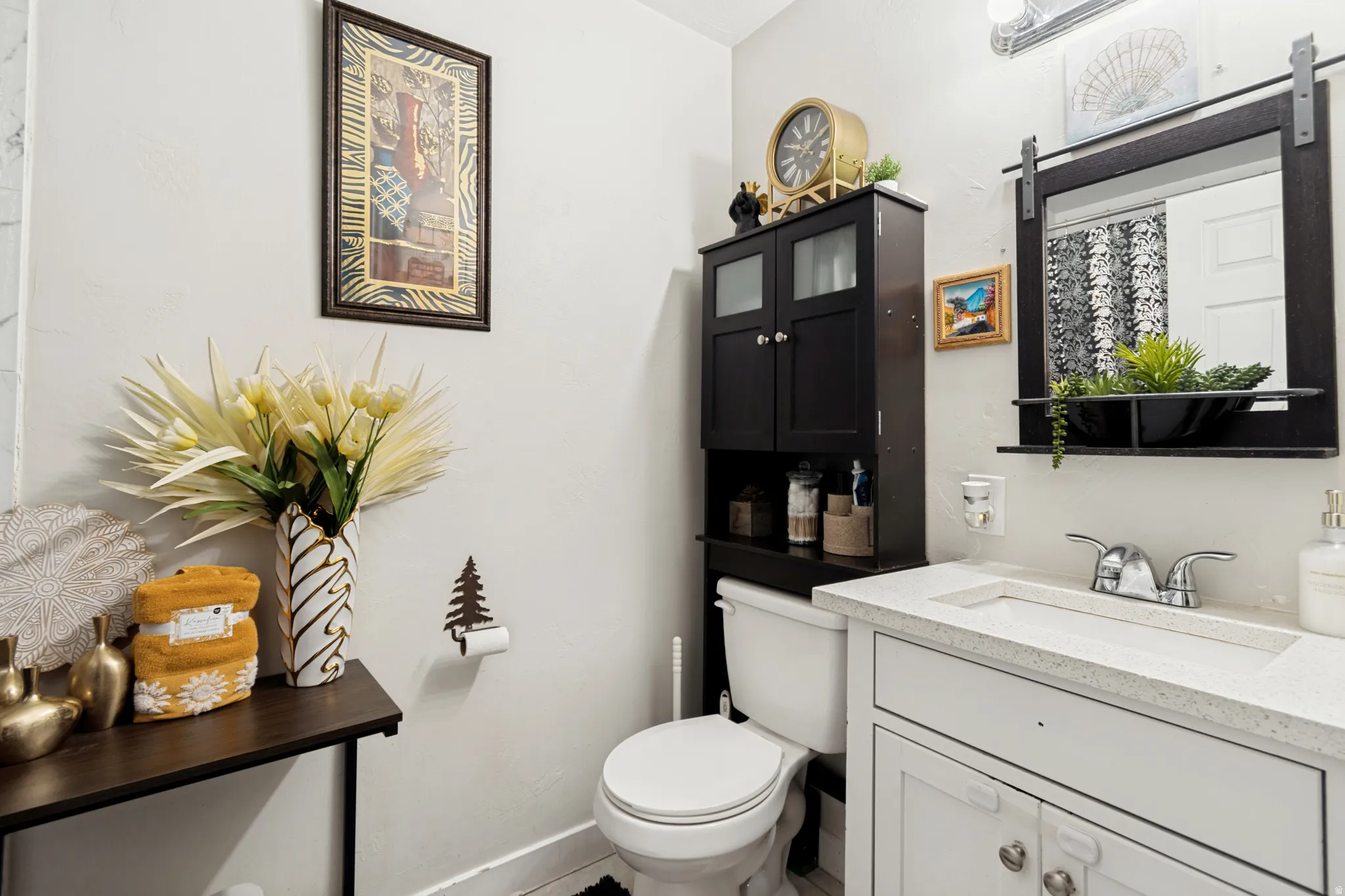 Bathroom vanity featuring a light-colored countertop with an integrated sink, chrome-finish faucet, and white cabinetry