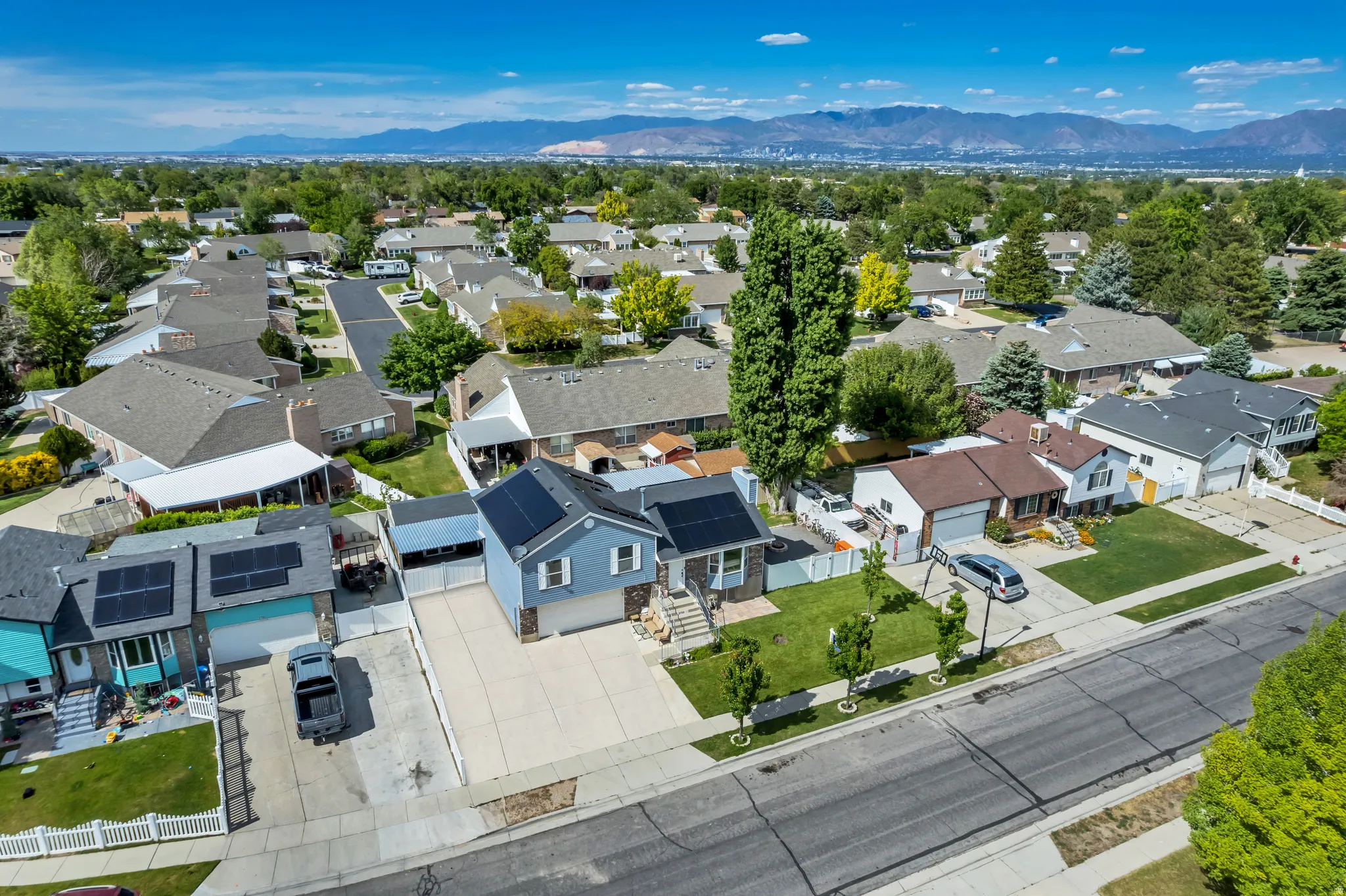 Residential neighborhood with mature trees and mountain backdrop