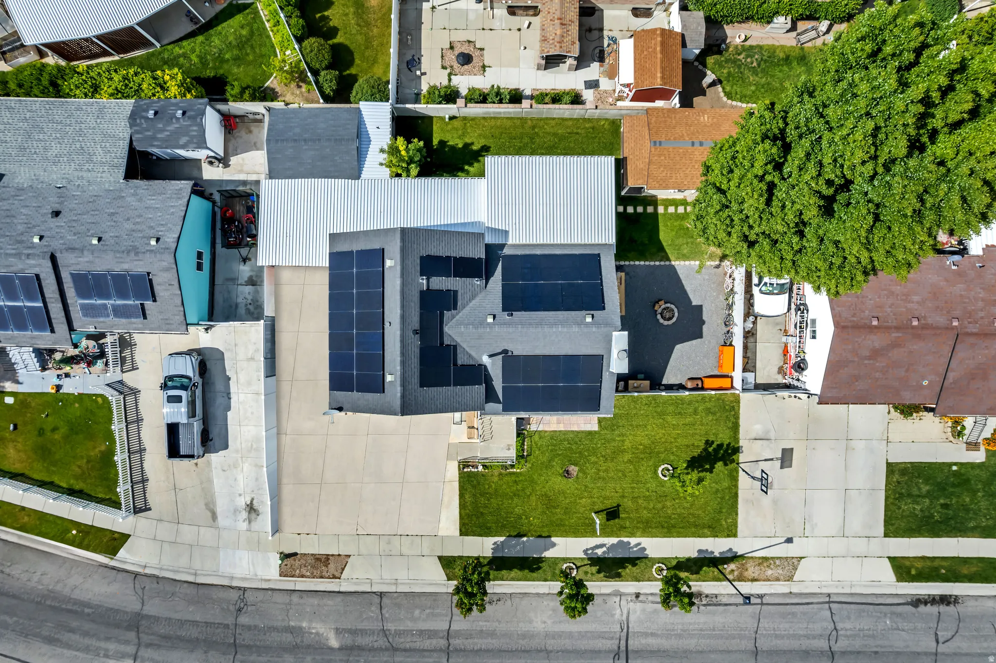 Overhead perspective showcasing a residential property with extensive solar panel installations on multiple roof sections