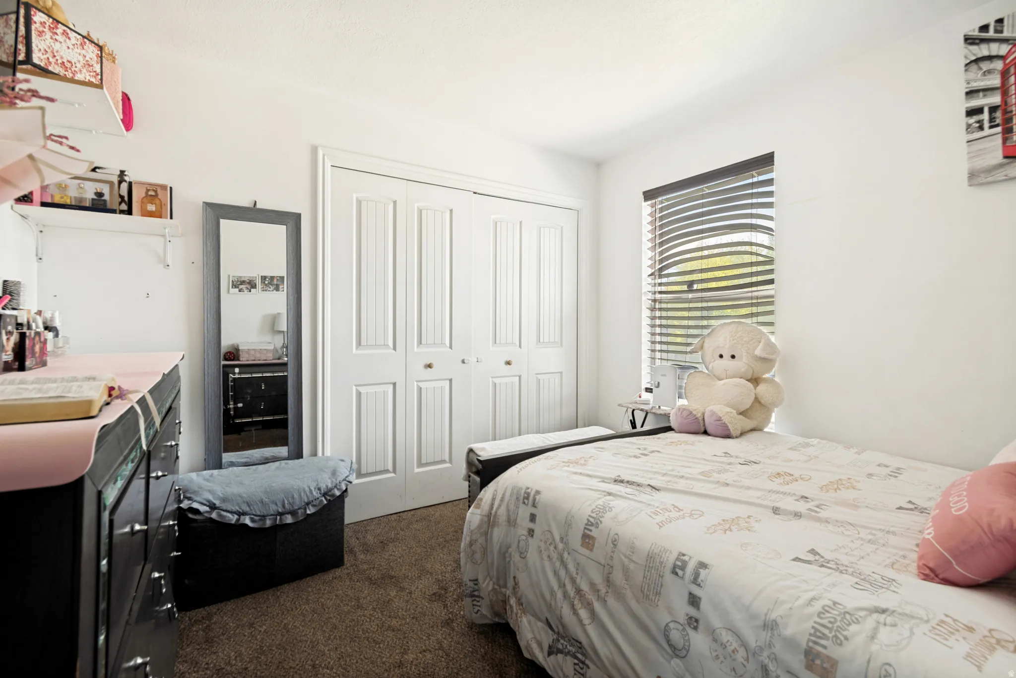 Bedroom featuring a paneled bi-fold closet, a window with horizontal blinds, and carpet flooring