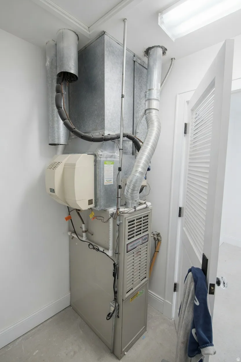 This is inside the walk-in closet on second floor, featuring a furnace system with integrated humidifier, extensive ductwork, and fluorescent ceiling lighting