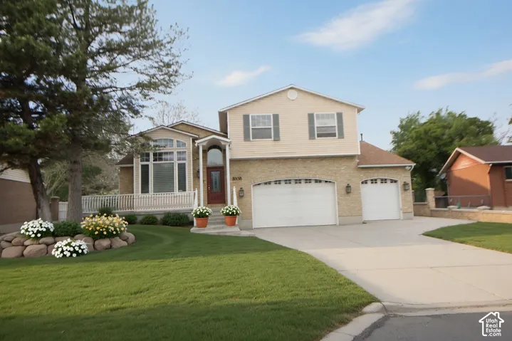 Two-story residence featuring a brick and siding exterior, a three-car garage, and an arched entryway