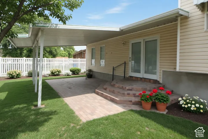Covered patio featuring brick paver flooring and steps