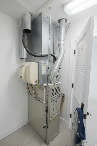 This is inside the walk-in closet on second floor, featuring a furnace system with integrated humidifier, extensive ductwork, and fluorescent ceiling lighting