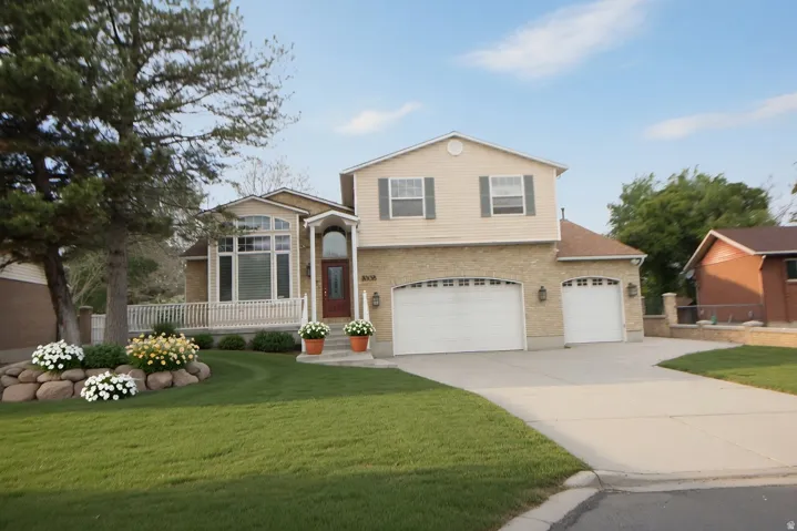 Two-story residence featuring a brick and siding exterior, a three-car garage, and an arched entryway