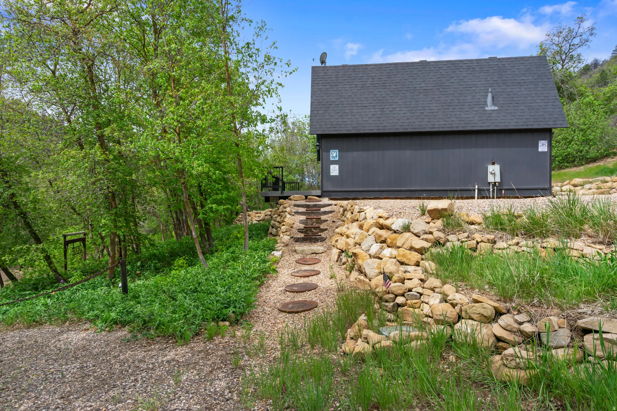 Cottage-style property featuring a dark exterior siding and a dark shingle roof
