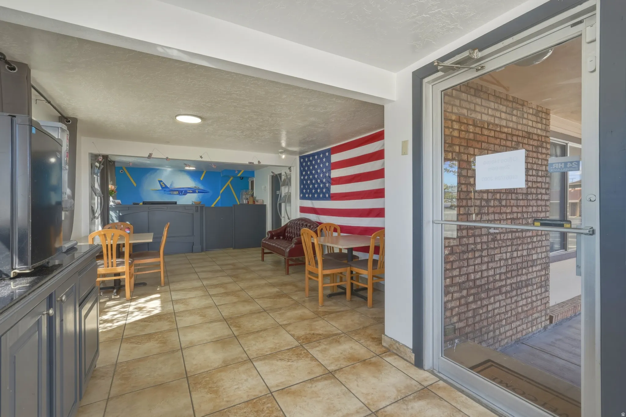 Tiled flooring extends through this interior space, featuring a counter with dark cabinetry and a wall mural