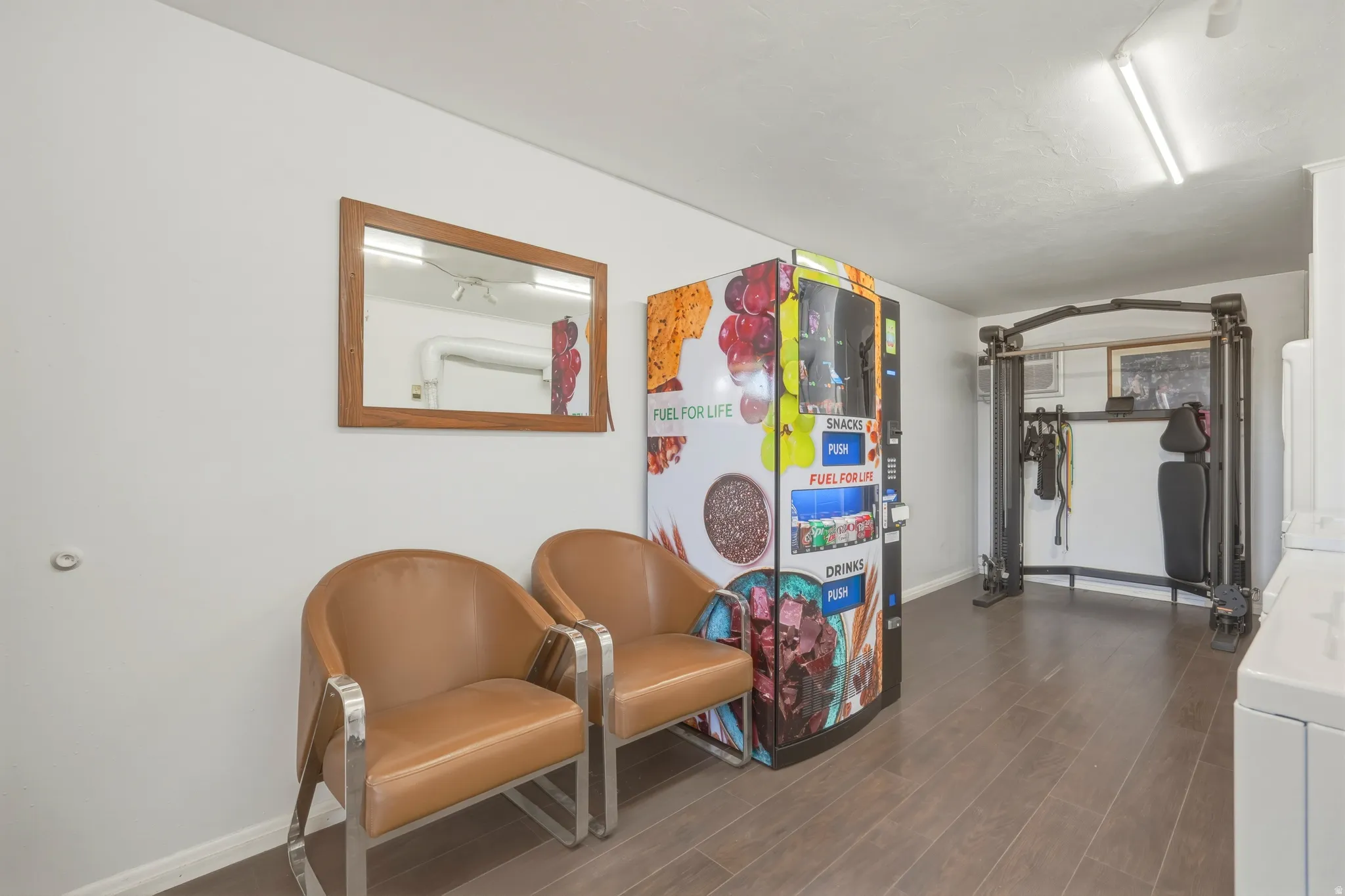 Versatile interior space featuring wood-finish flooring, white walls, and bright overhead lighting