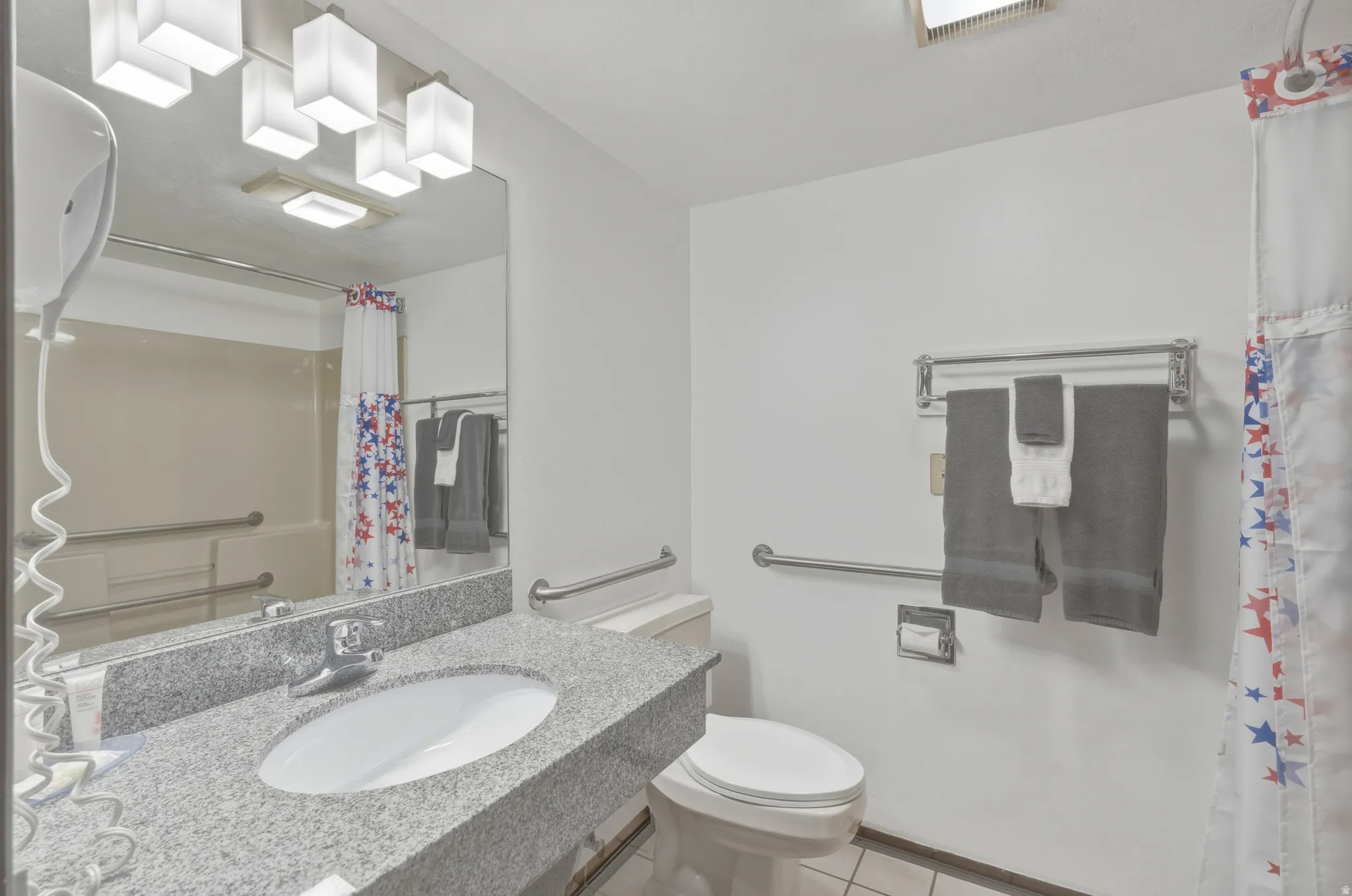 Bathroom featuring a vanity with a granite countertop, undermount sink, and chrome faucet