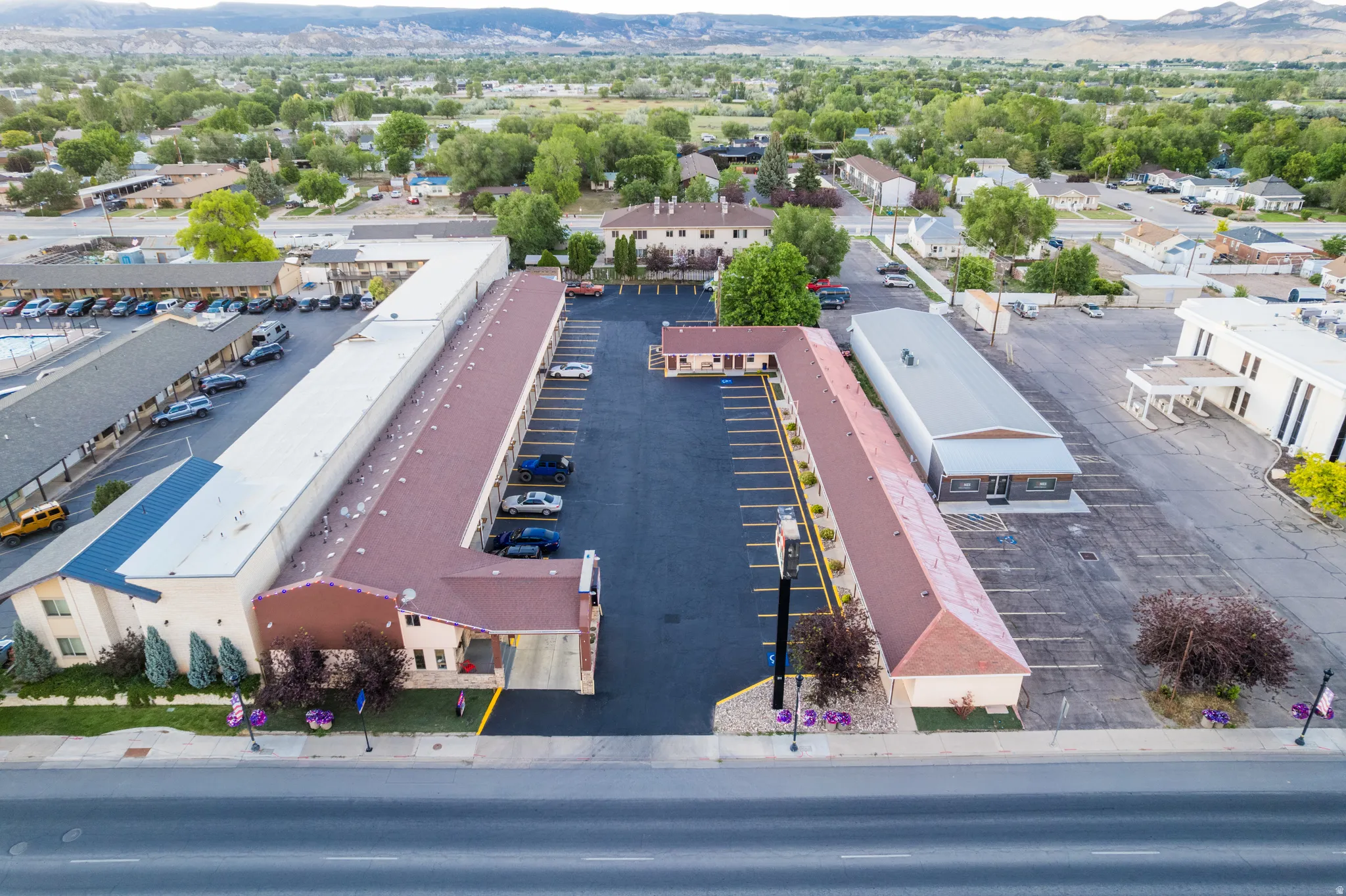Large commercial property featuring extensive paved parking areas, multiple multi-story structures with pitched roofs, and a prominent roadside presence