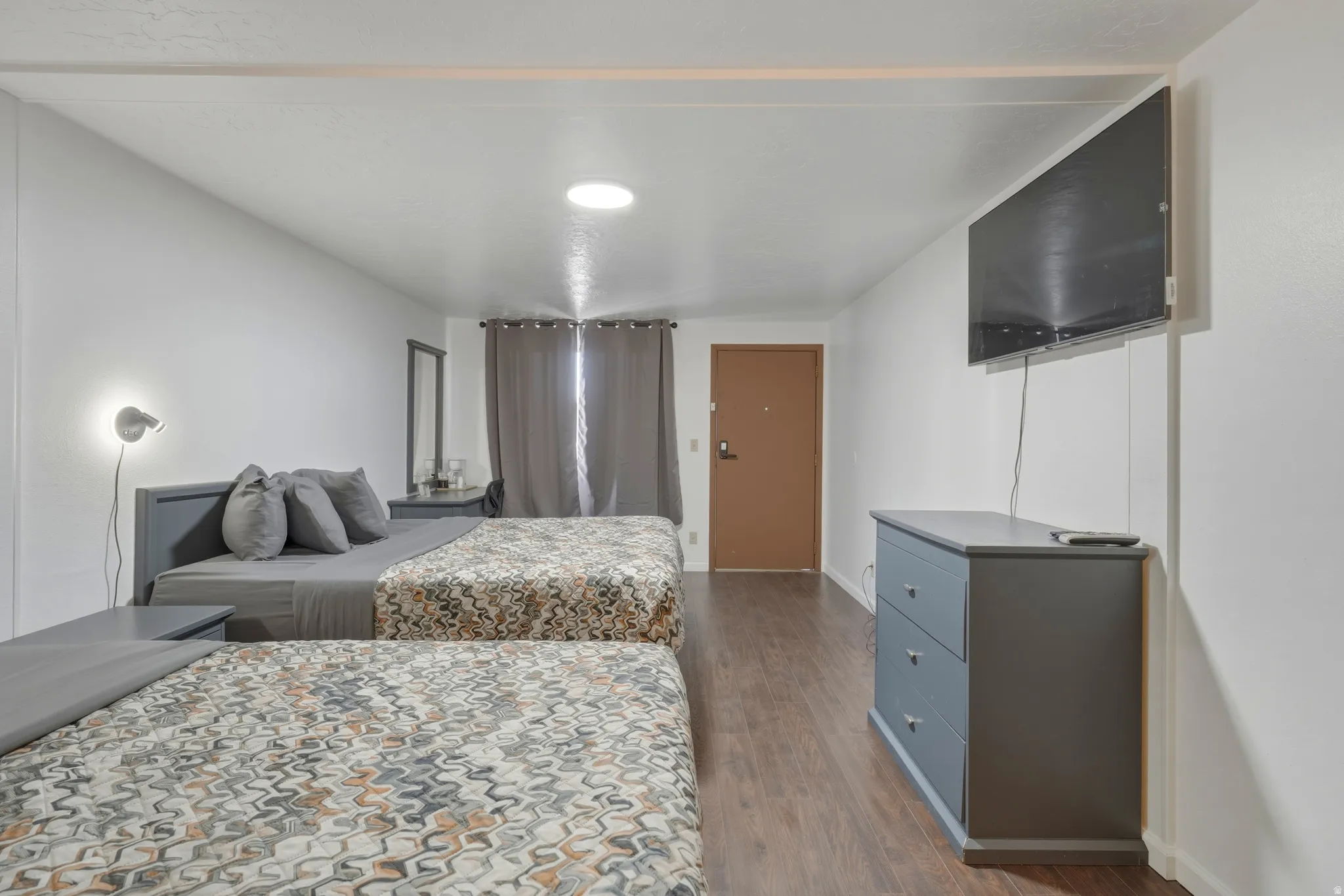 Bedroom featuring wood-finish flooring, white walls, and a recessed ceiling light