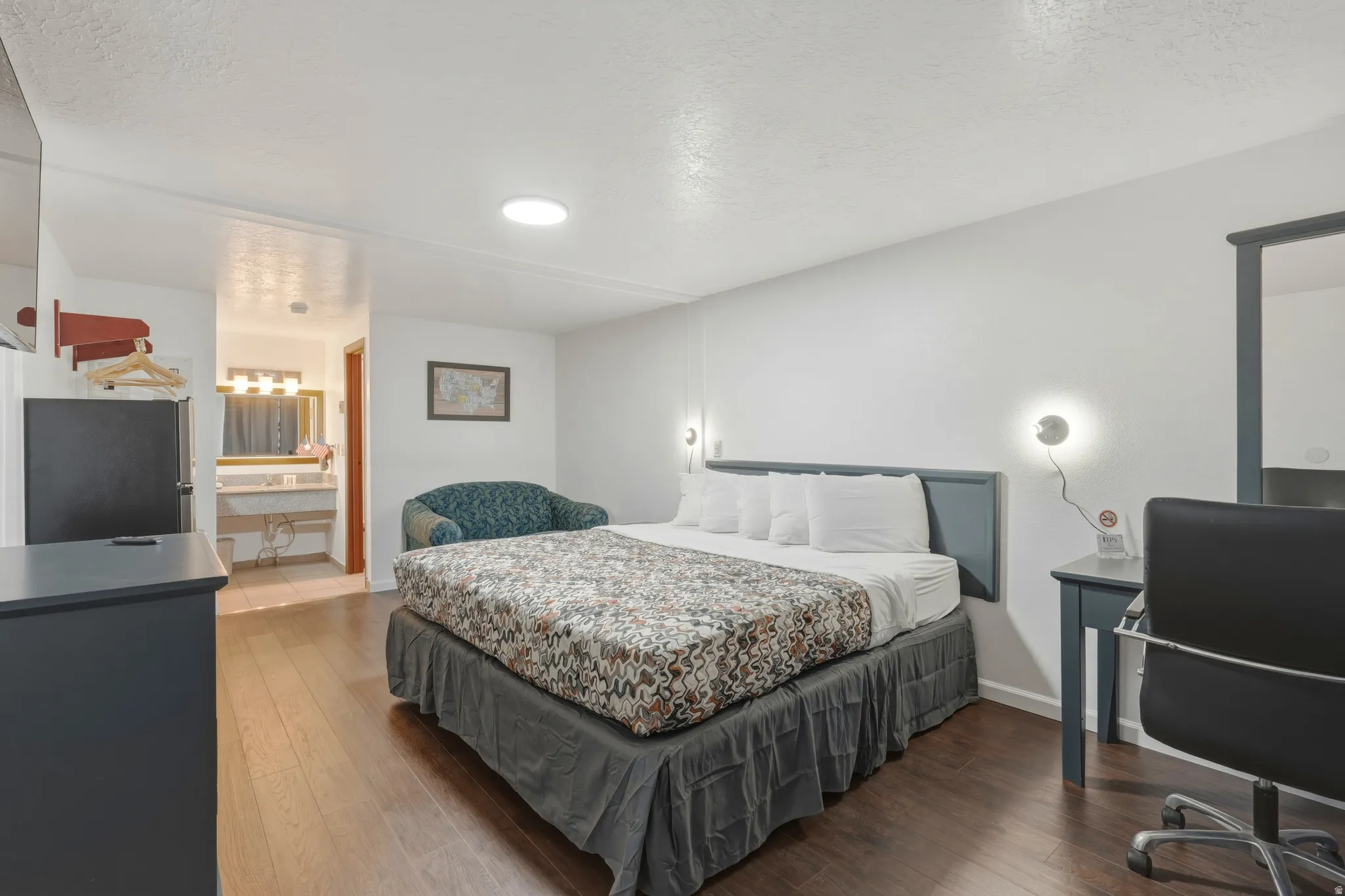 Bedroom featuring wood-finish flooring, recessed ceiling lighting, and wall-mounted sconces