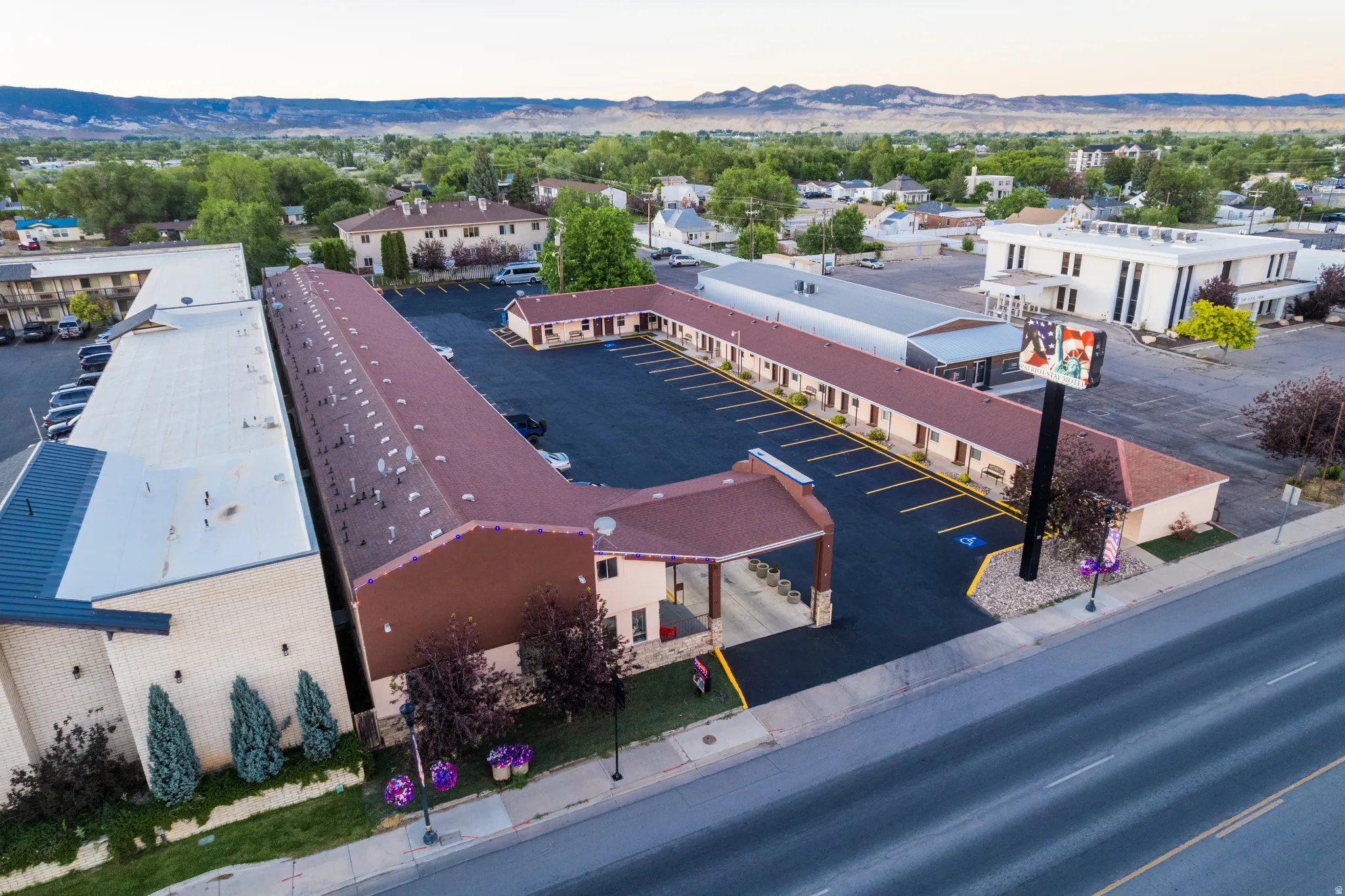 Commercial property featuring multiple buildings with brown shingle roofing and light-colored siding