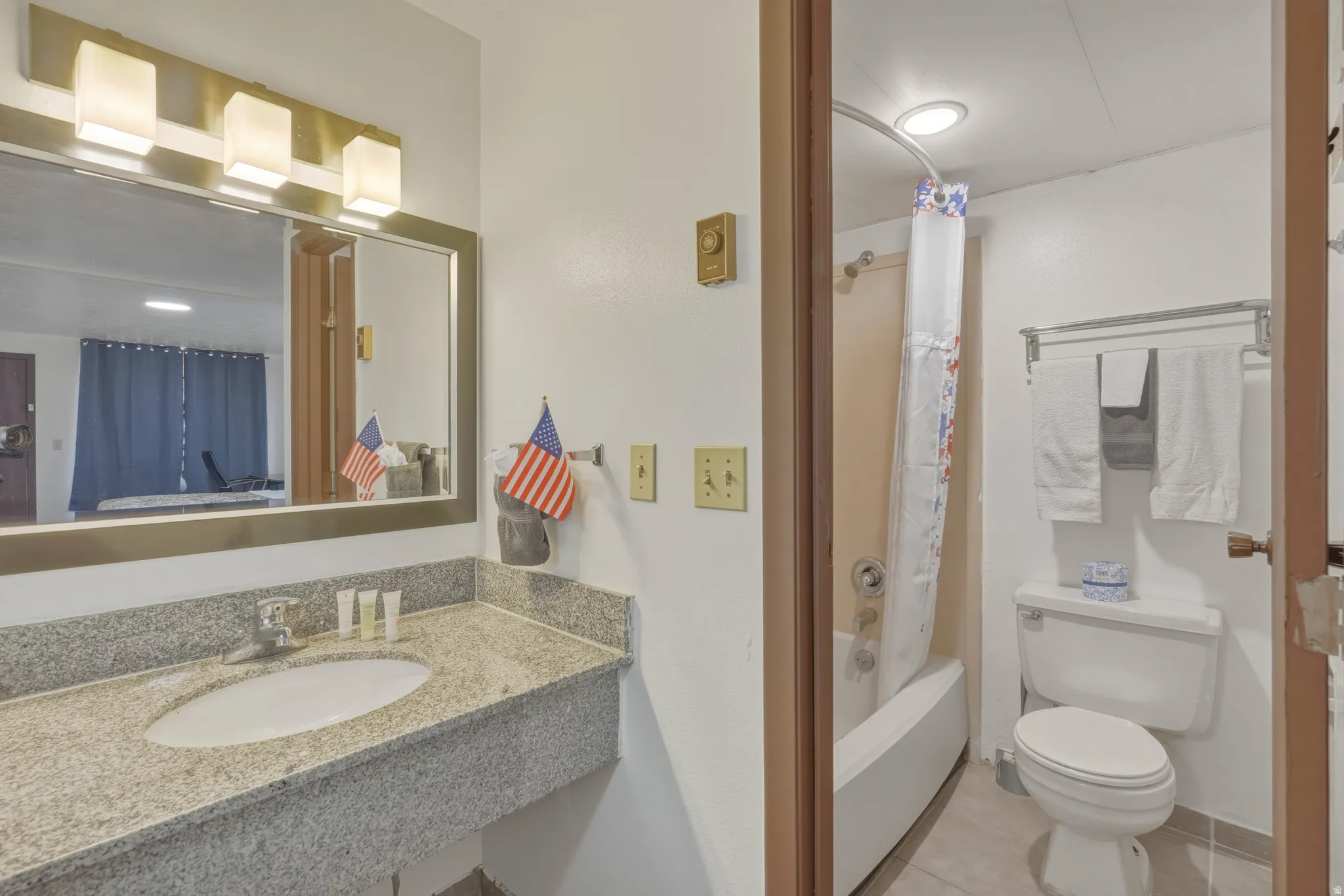 Bathroom featuring a vanity with a light granite countertop and integrated sink