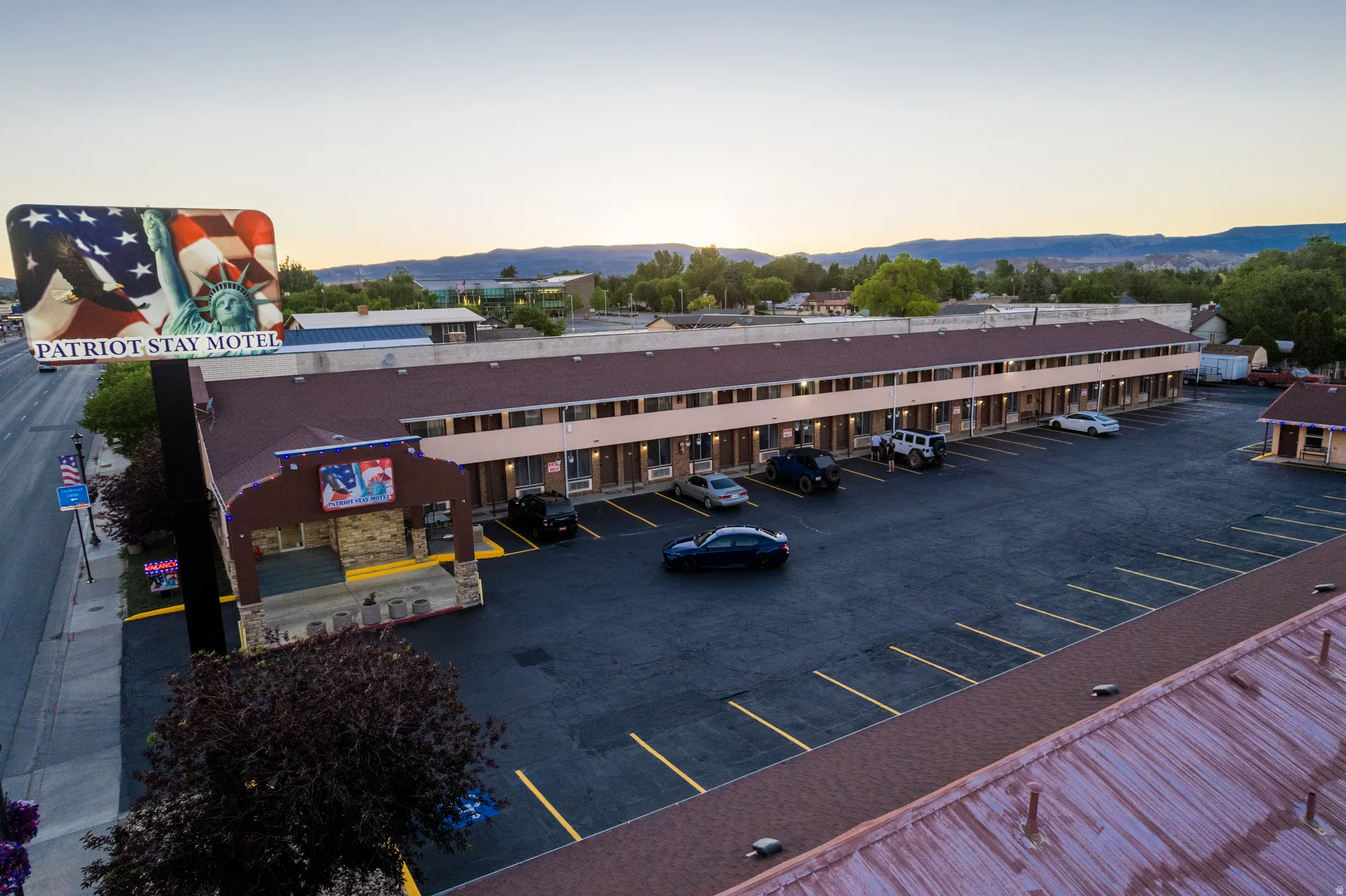Commercial property featuring a multi-unit building with a large paved parking area