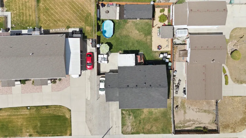 Expansive property featuring a large main residence with a gray shingle roof, a detached garage with a white awning, and an additional backyard structure