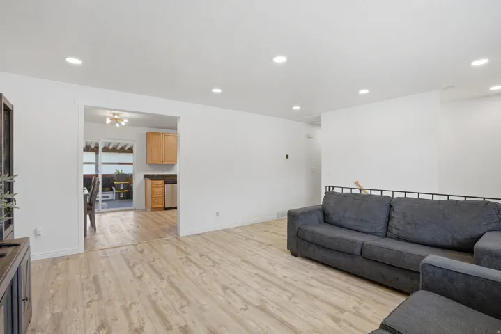 Expansive room featuring wood-finish flooring, recessed lighting, and a neutral color palette