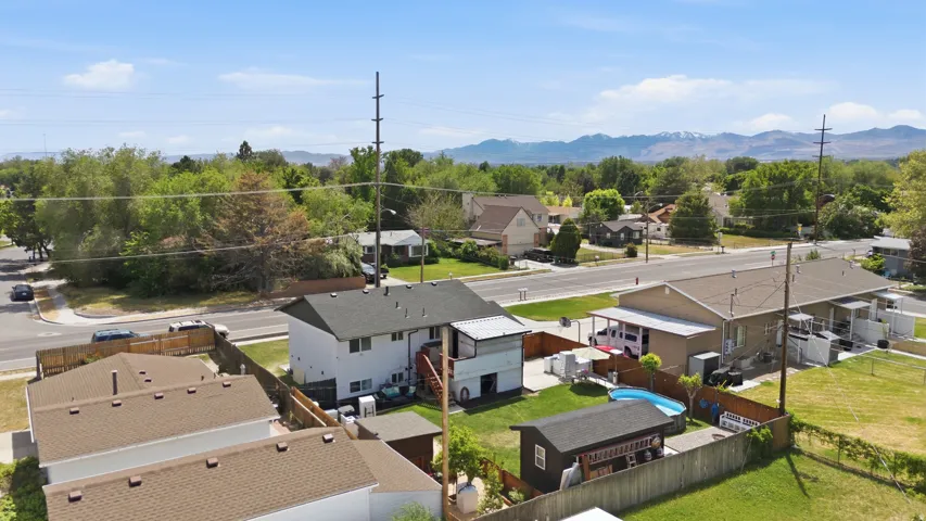 Expansive lot featuring a detached residential structure, a fenced backyard, an above-ground pool, and a storage shed