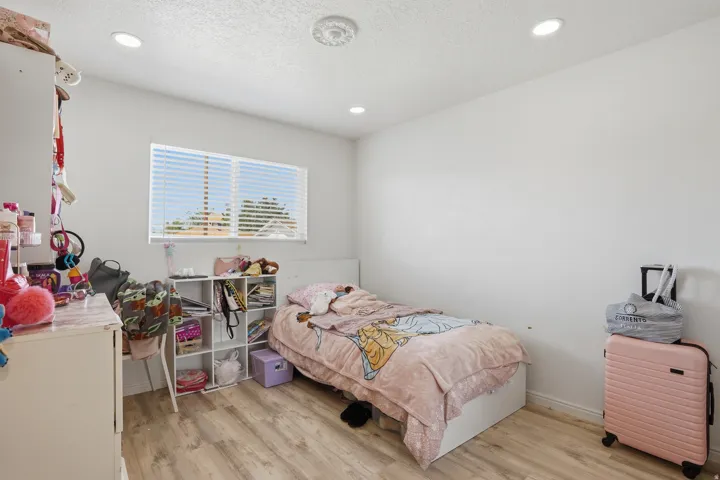 Recessed lighting illuminates this room featuring wood-finish flooring