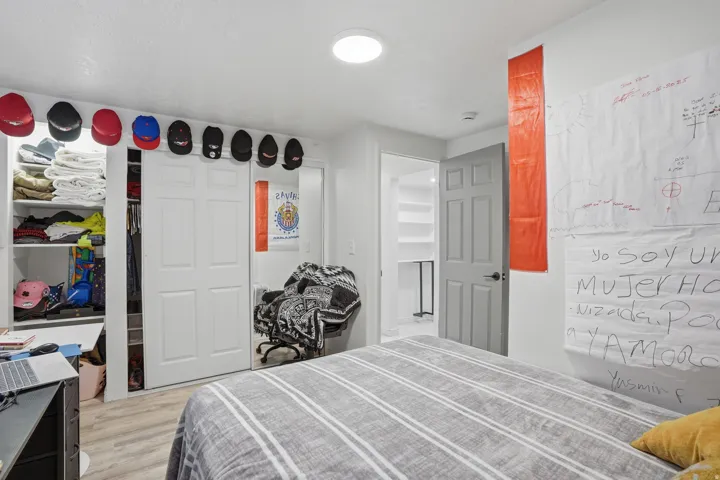 Bedroom featuring light wood-finish flooring and a white ceiling with a flush-mount light fixture